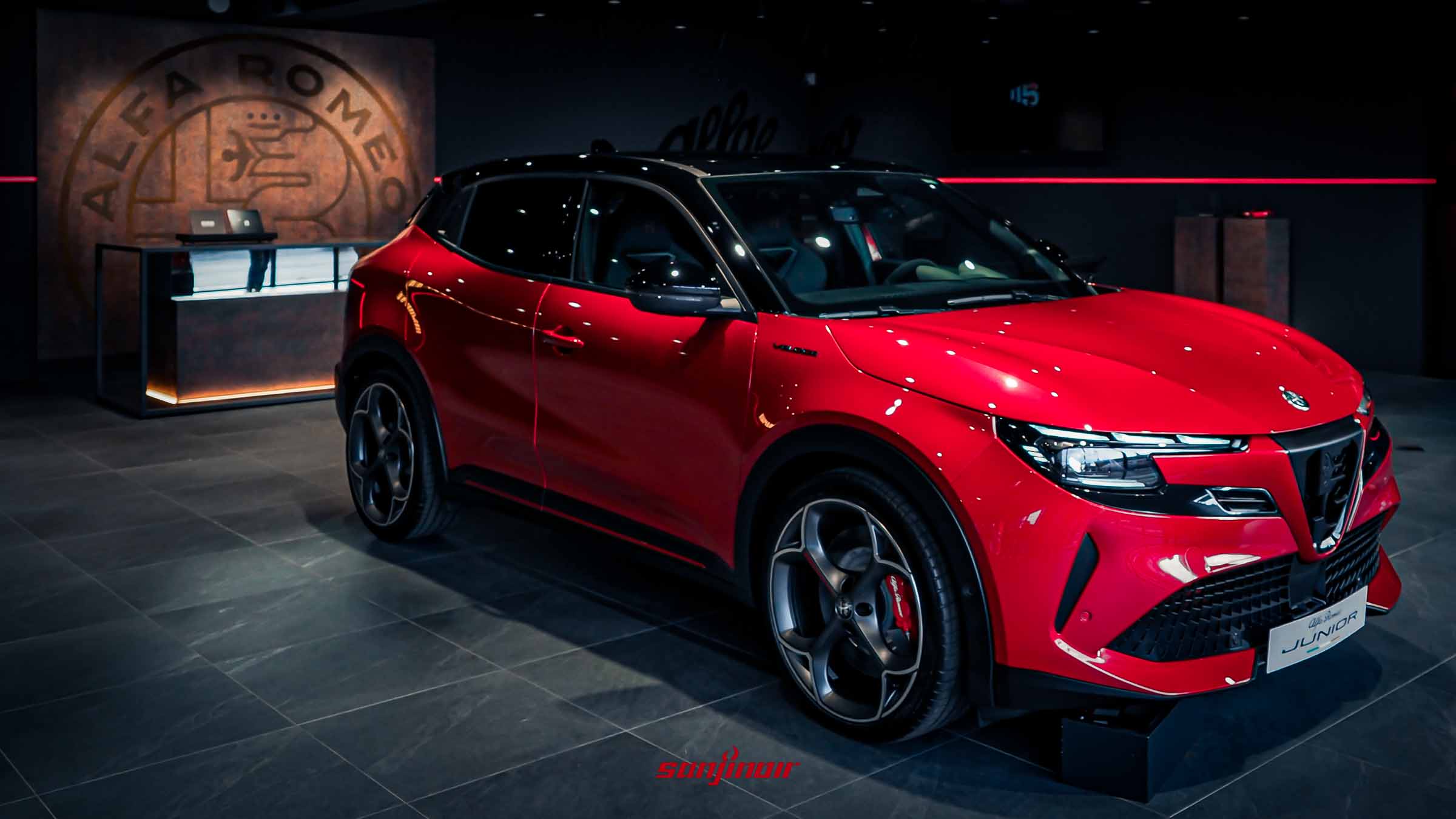 紅色Alfa Romeo Junior停放在桃園旗艦品牌中心的Alfa Romeo品牌牆前方。