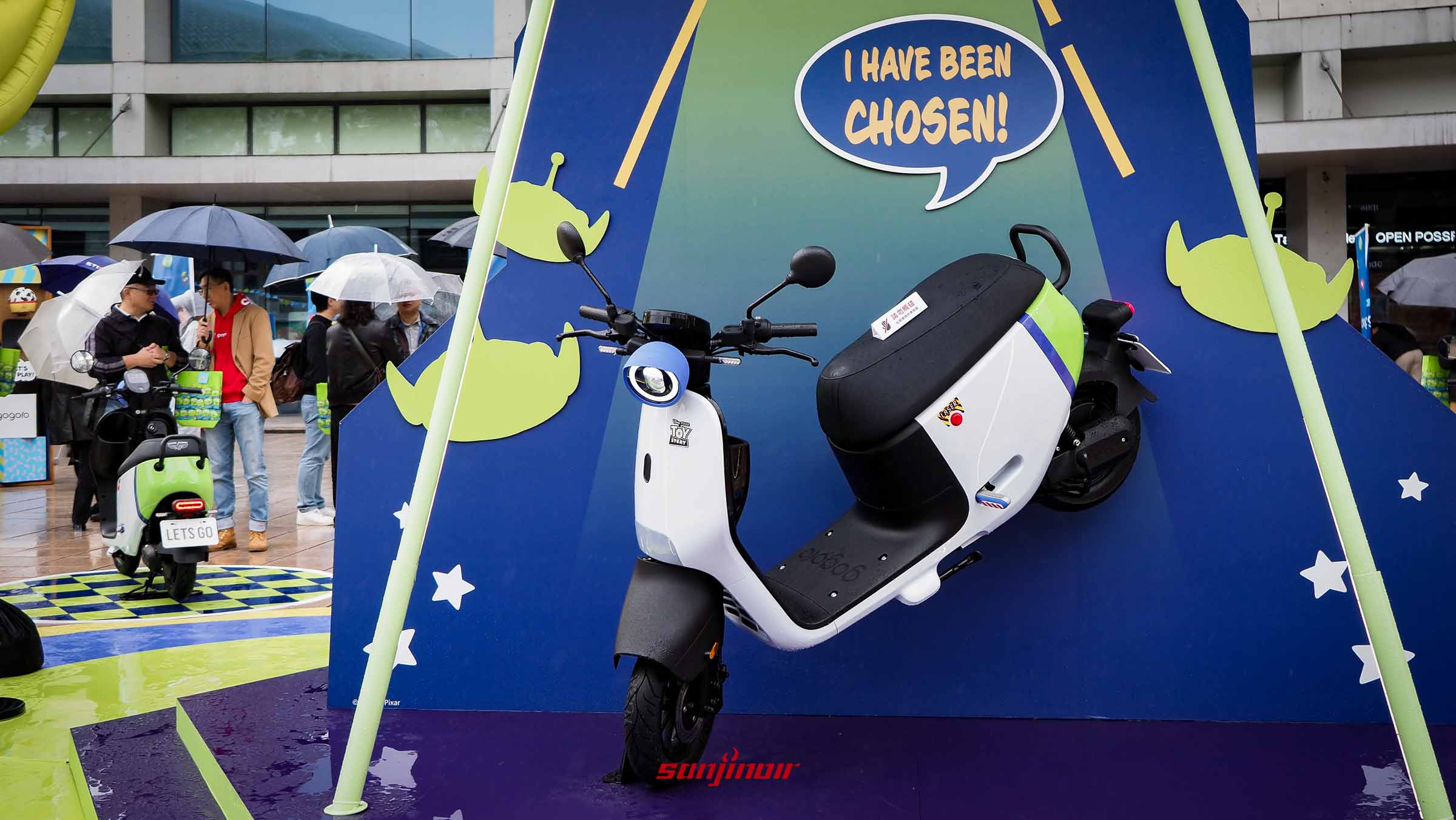 Gogoro EZZY 500浩瀚宇宙號機車停放在三眼怪主題造景前，車身採白綠紫配色。