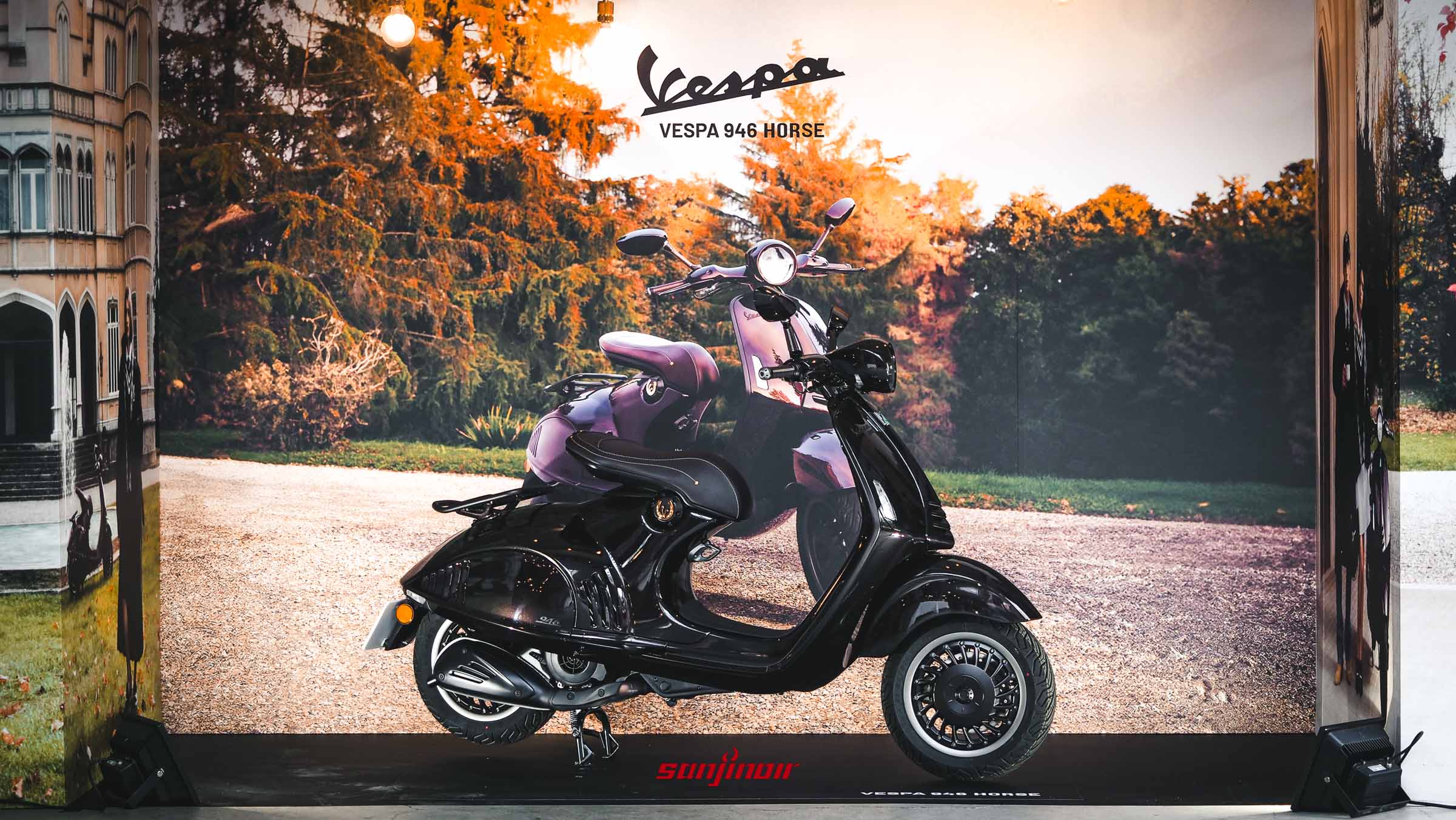 Vespa 946馬年特仕版摩托車的展示圖片。全車身為全黑亮面配有單座墊，停放在印有Vespa 946 HORSE字樣與馬匹圖案的活動背板前，視角為左前方斜視。