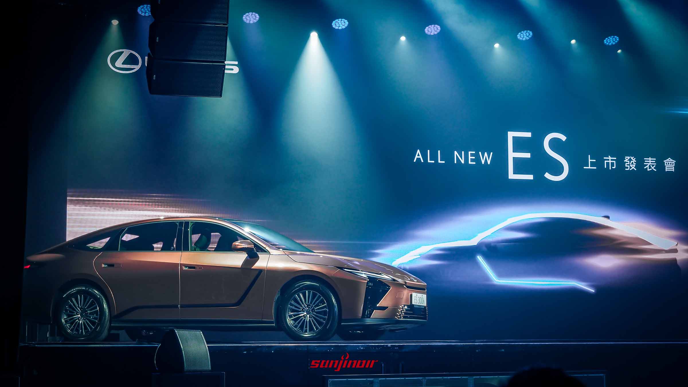 舞台上展示的全新銅色Lexus ES側面照，背景帶有ALL NEW ES上市發表會字樣與車身發光輪廓。
