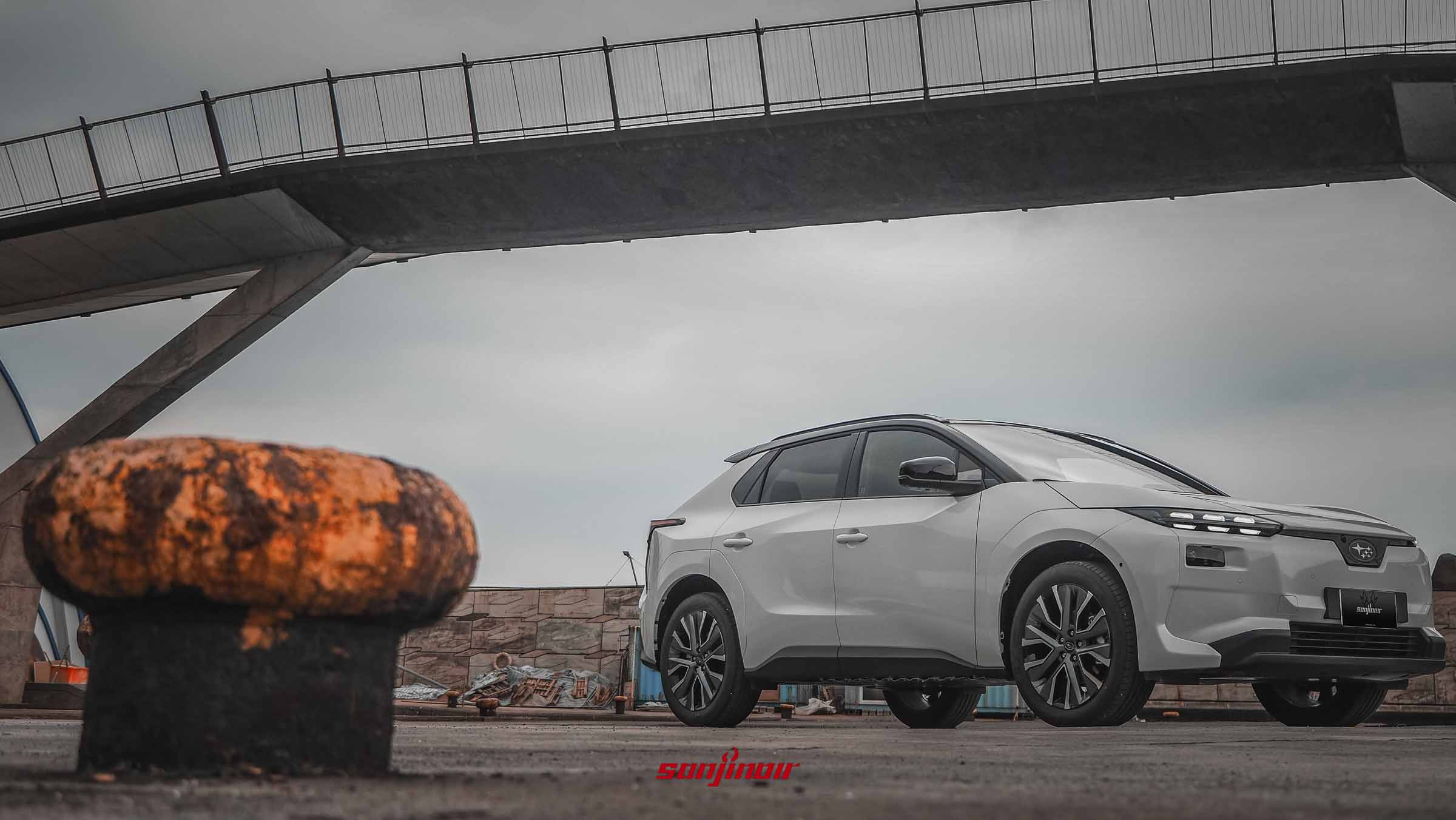 白色2026年Subaru Solterra XT停放於港邊，展現同色烤漆輪拱與封閉式車頭設計。