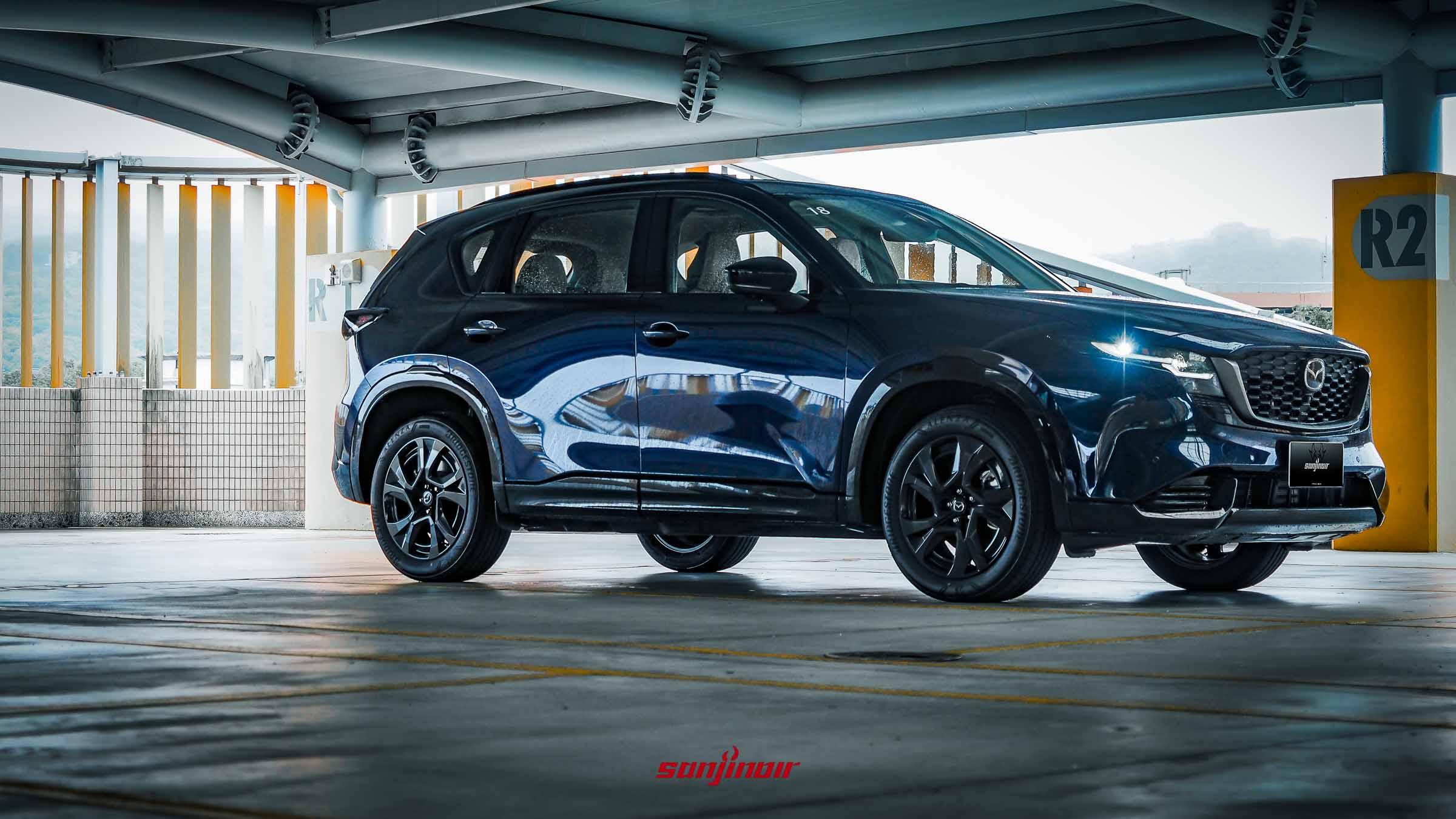 深藍色MAZDA CX-5停放於半露天停車場的側前方面貌。