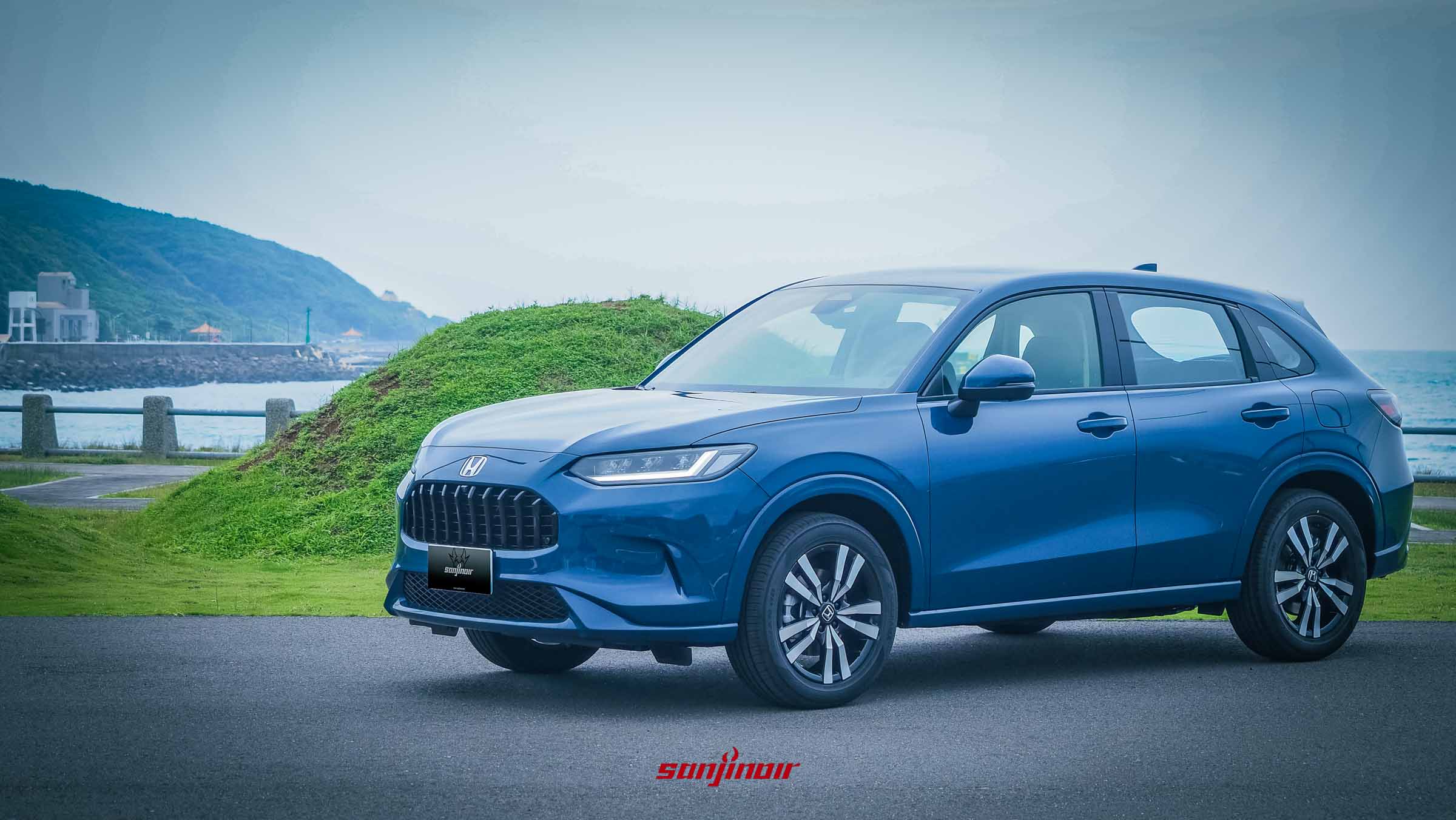 2026 HONDA ZR-V e:HEV藍色車頭側視角，停放於海岸邊。