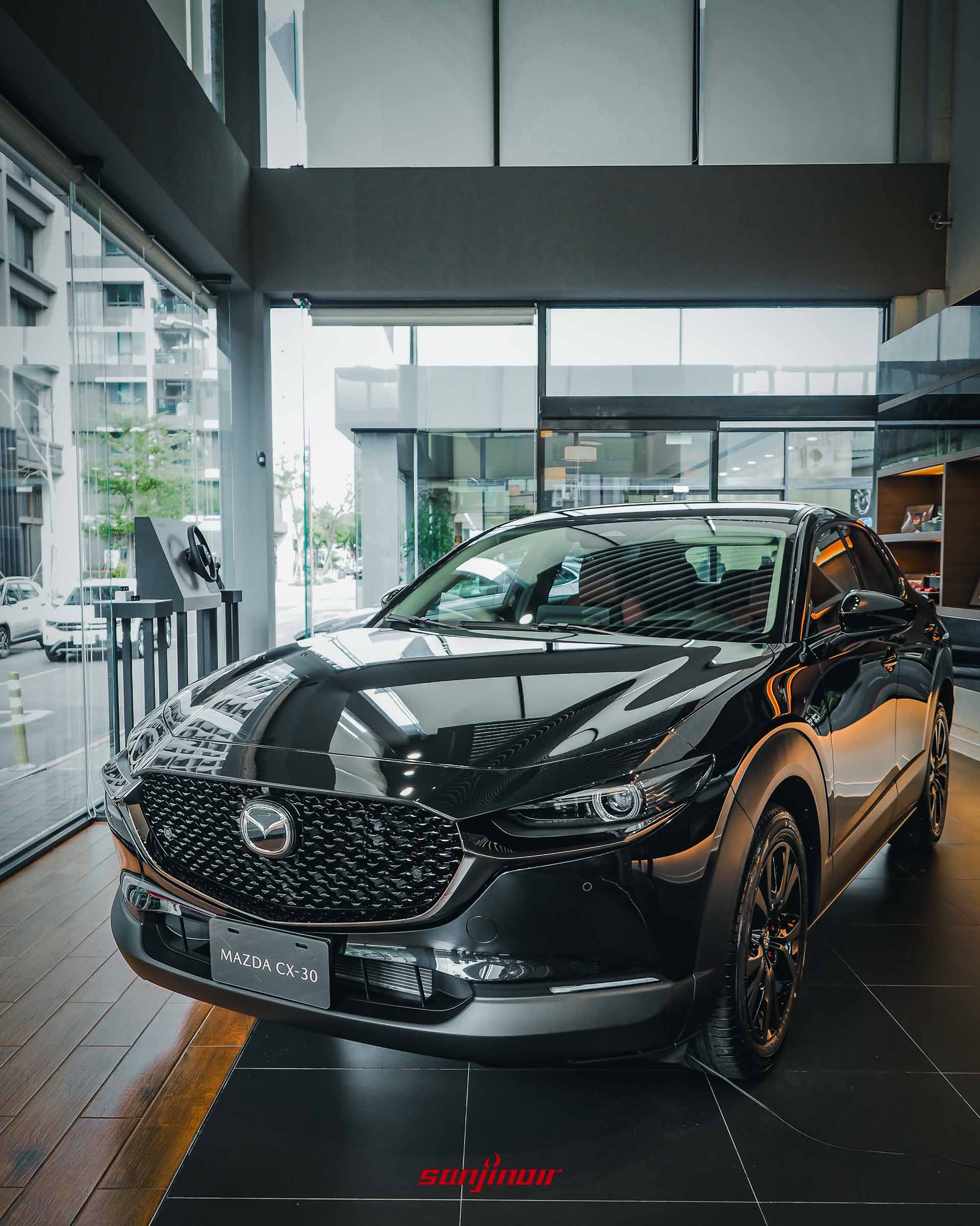 黑色 MAZDA CX-30 HOMURA 跨界休旅車，具備爍黑魂動之翼等黑化外觀套件，停放於 MAZDA 展間內。