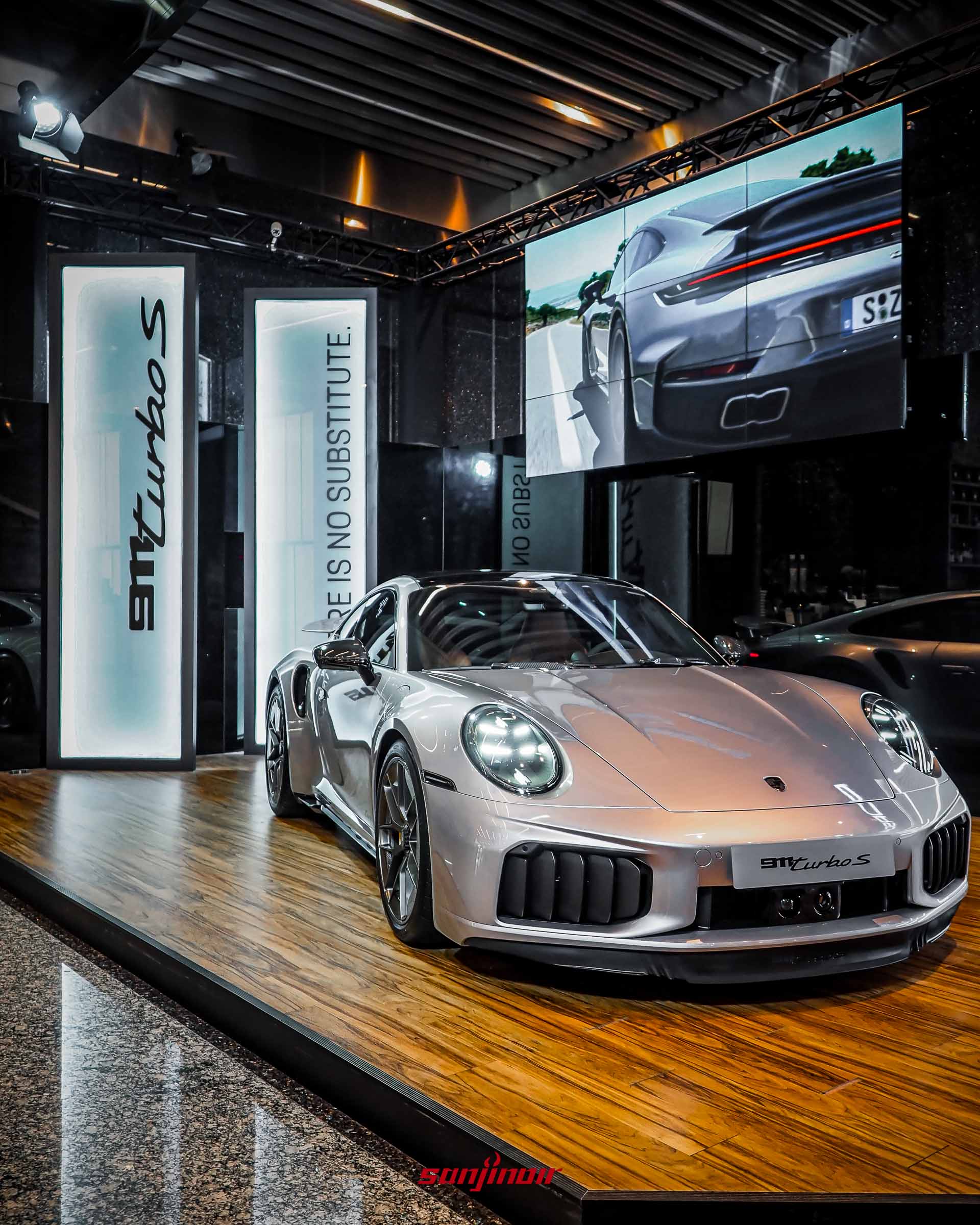 Porsche 911 Turbo S實車於展台正前方視角,背景有品牌標語。