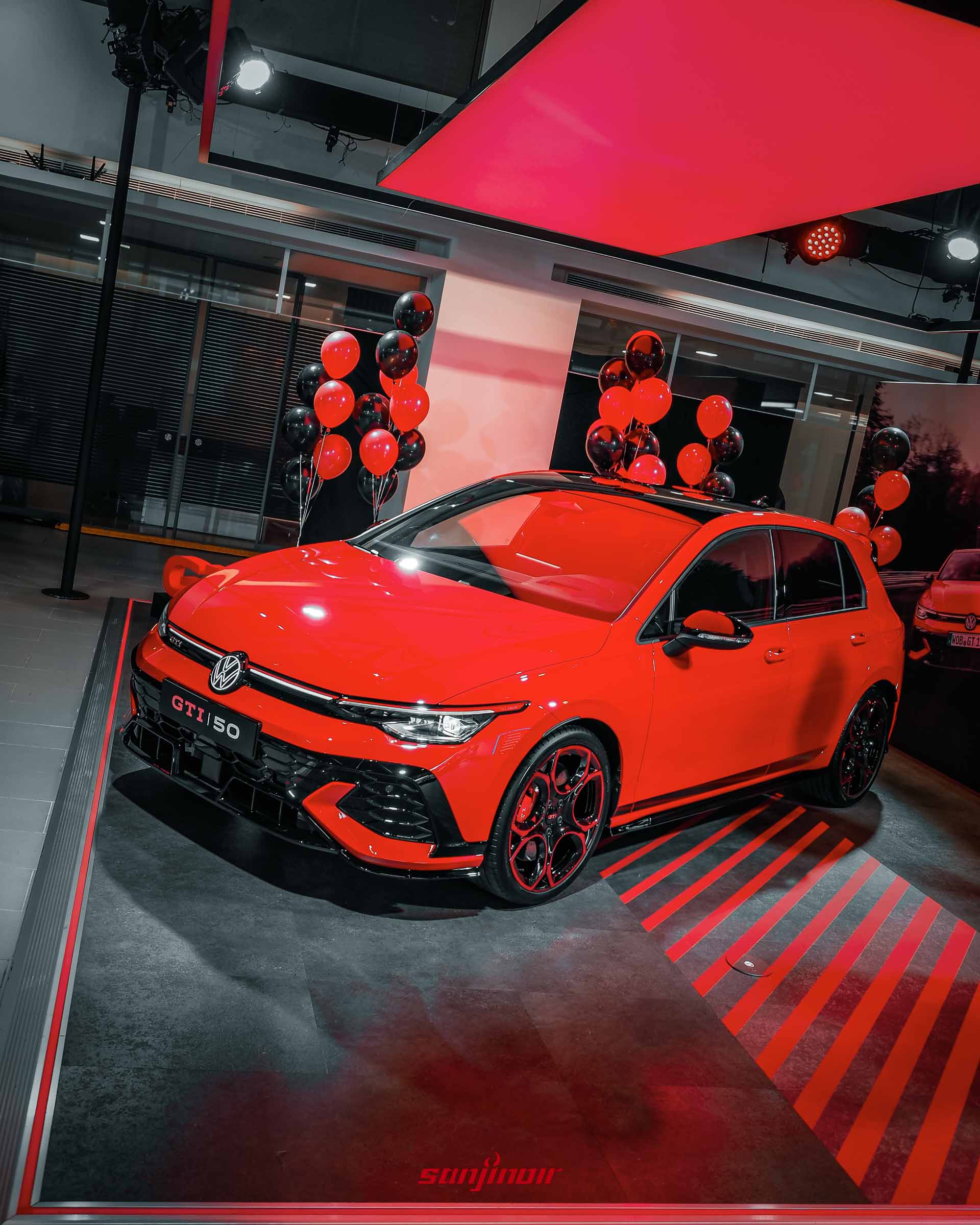 紅色Golf GTI EDITION 50前側高角度俯瞰照，展示黑化車頂、引擎蓋線條與具備大型進氣壩的運動化前保桿。