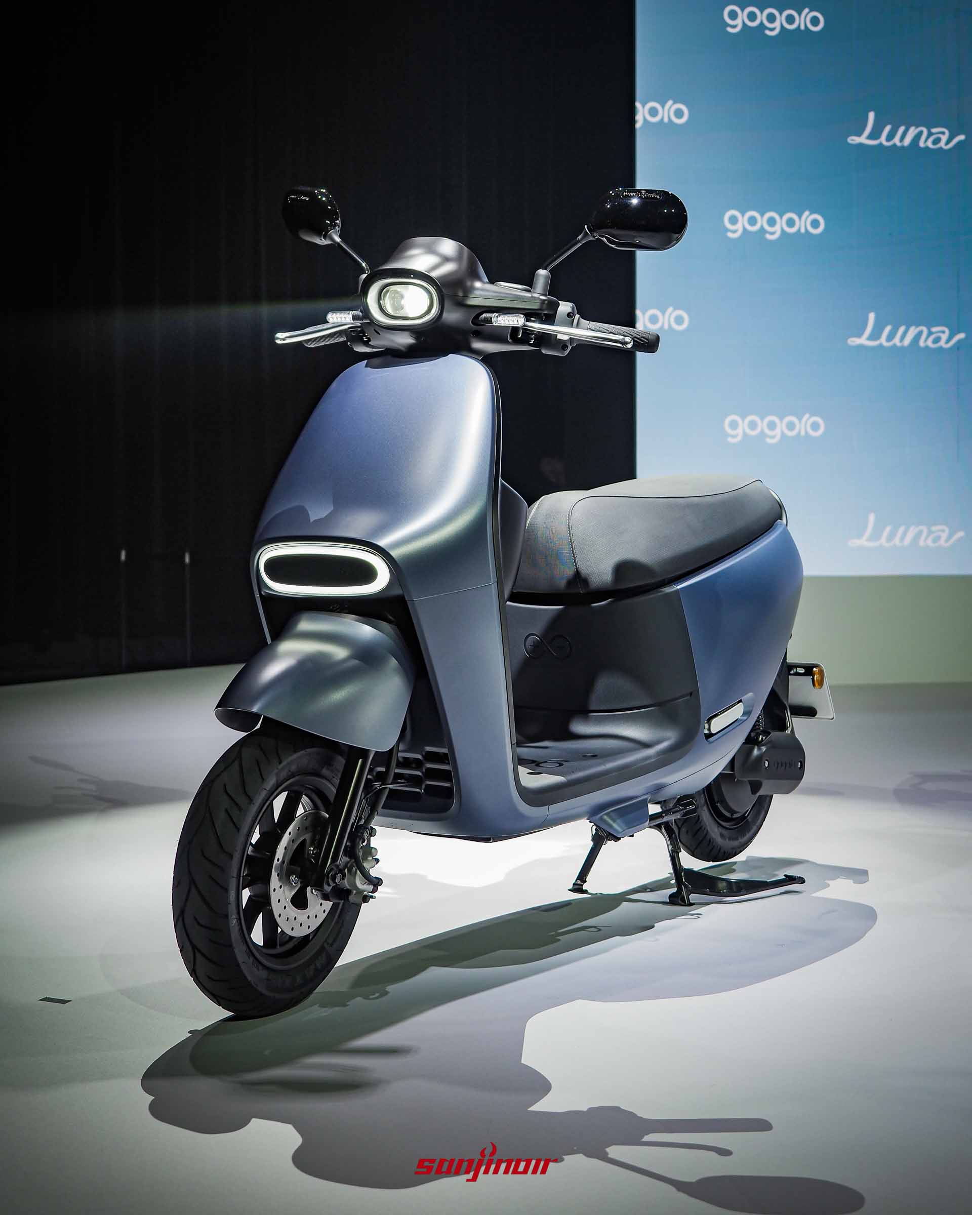 Gogoro Luna正面斜角照片，車頭下方的弧形月環位置燈亮起，背景為Gogoro Luna發表會背板。