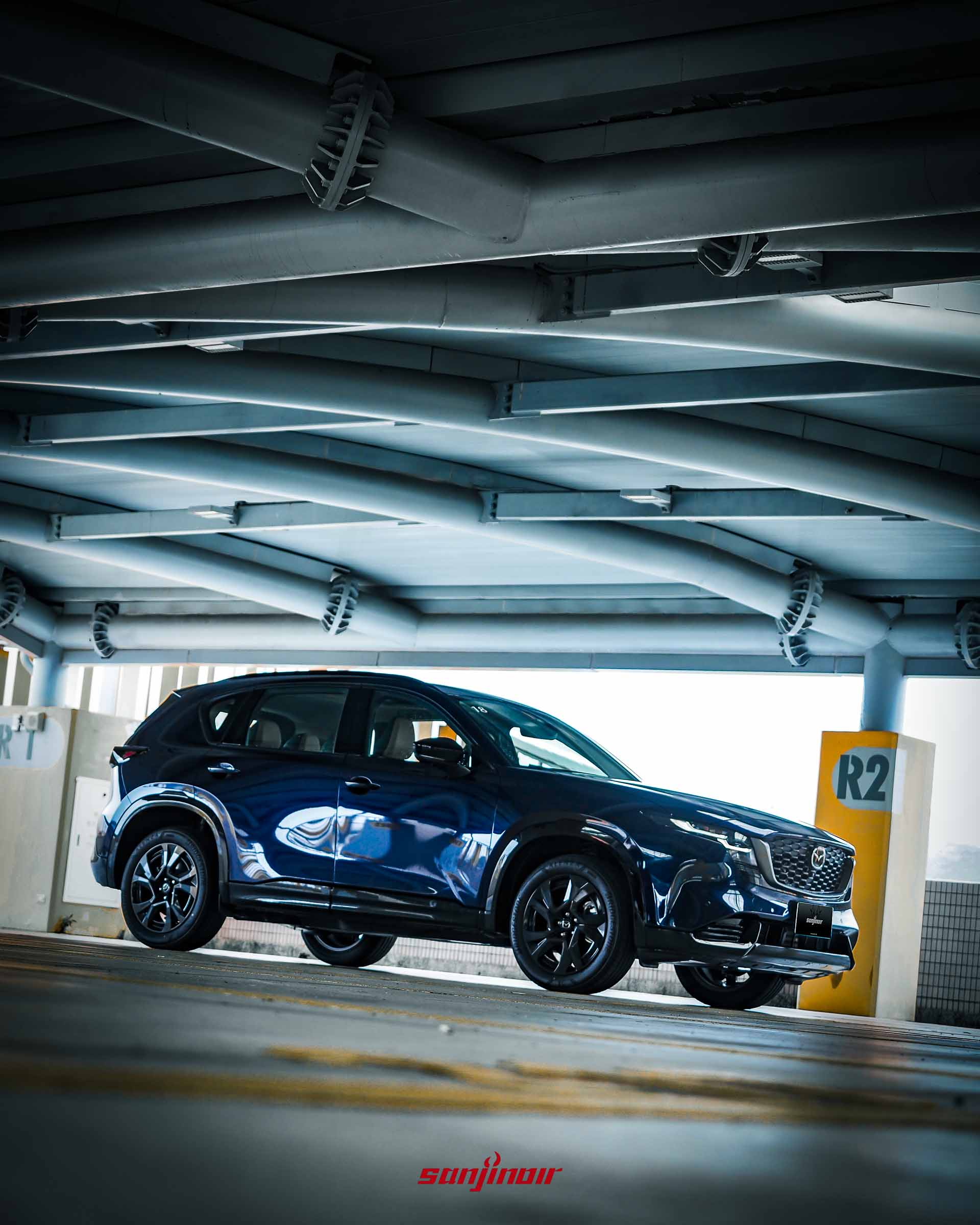 從較低視角拍攝深藍色MAZDA CX-5側前方的車身比例與光影反射。