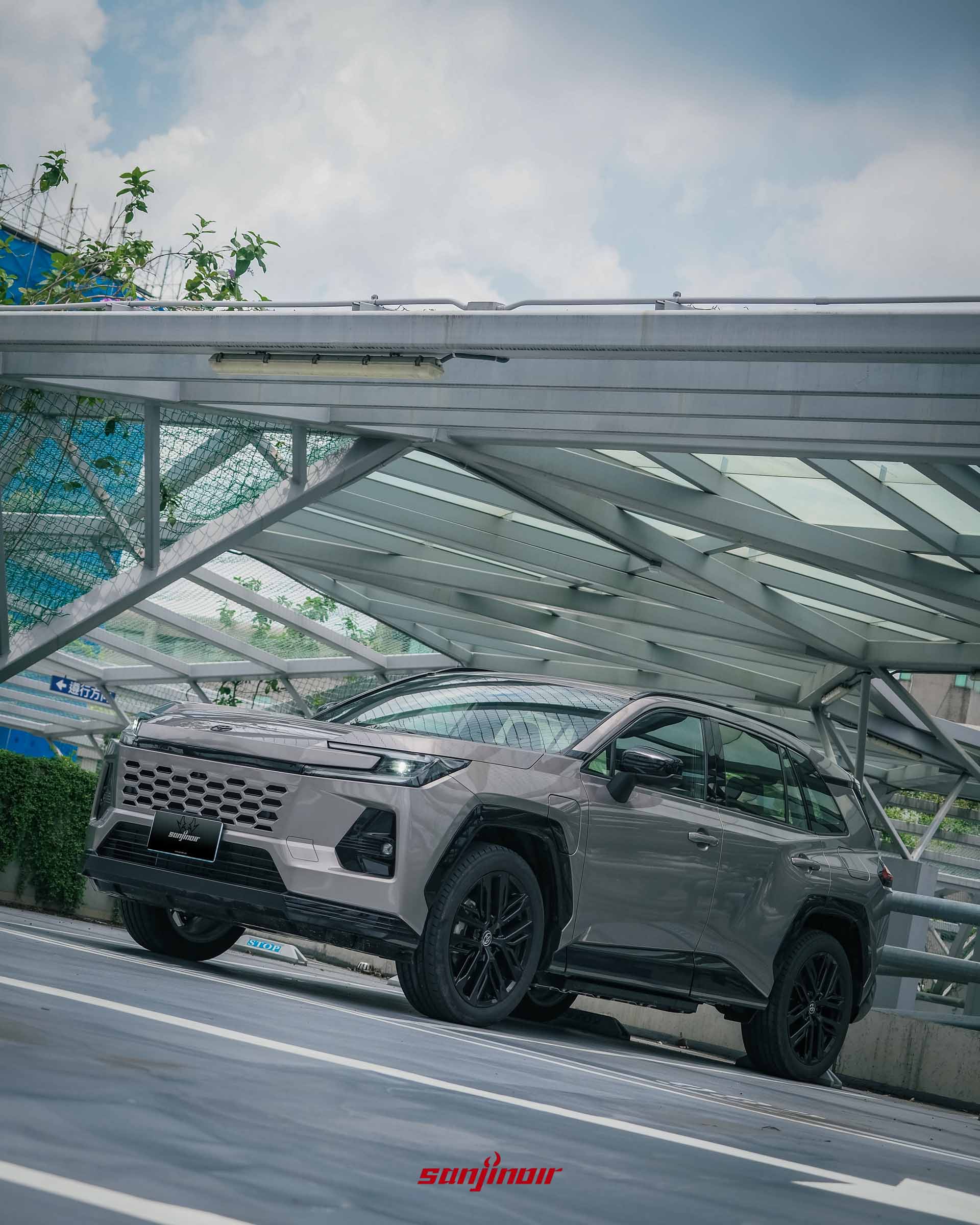 Toyota RAV4 PHEV左前車側低角度特寫,突顯20吋馭黑鋁圈與亮黑色防刮材質輪拱。