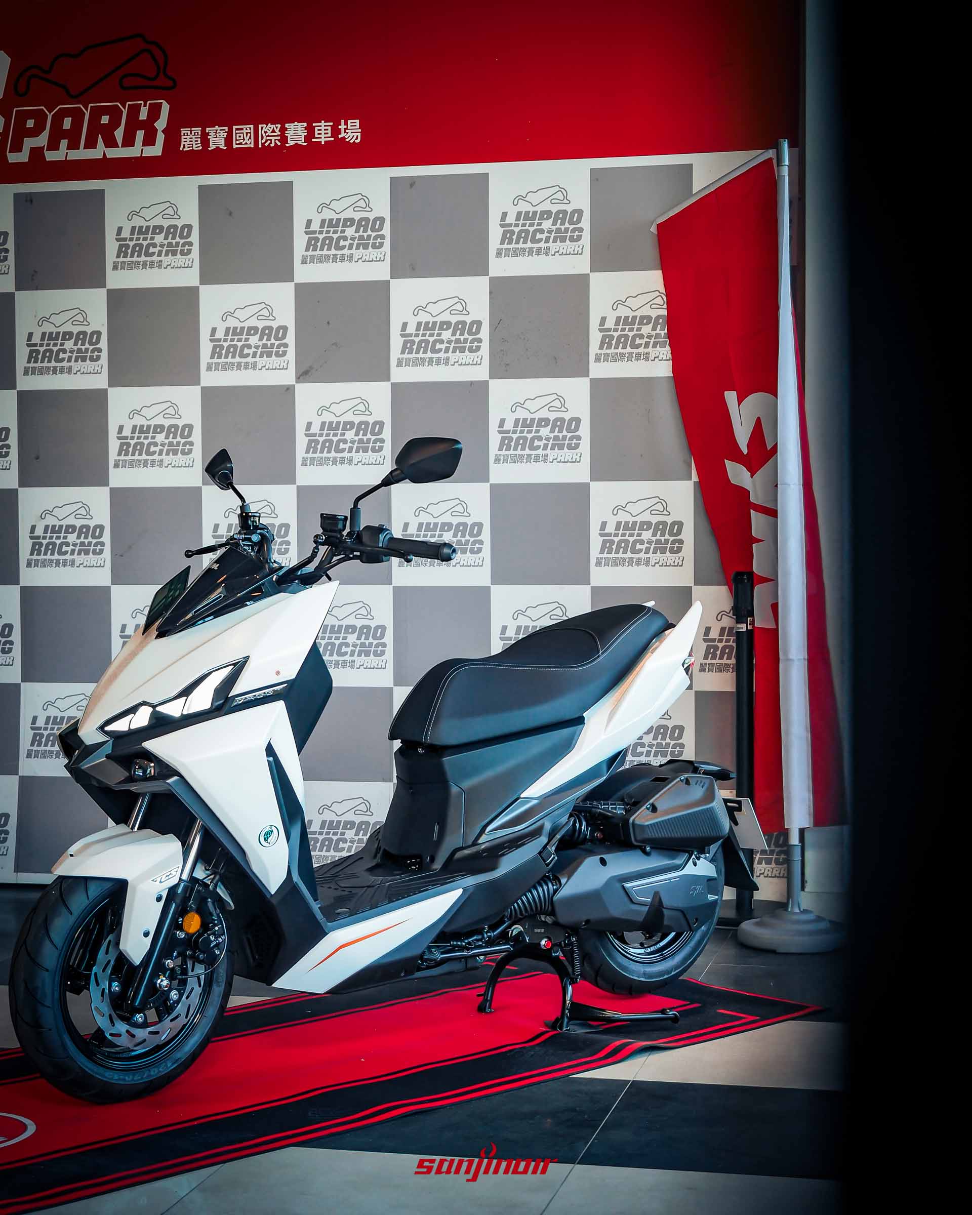 2026年式樣SYM DRGBT白色車款左側45度角全身照,背景為麗寶賽車場背板。