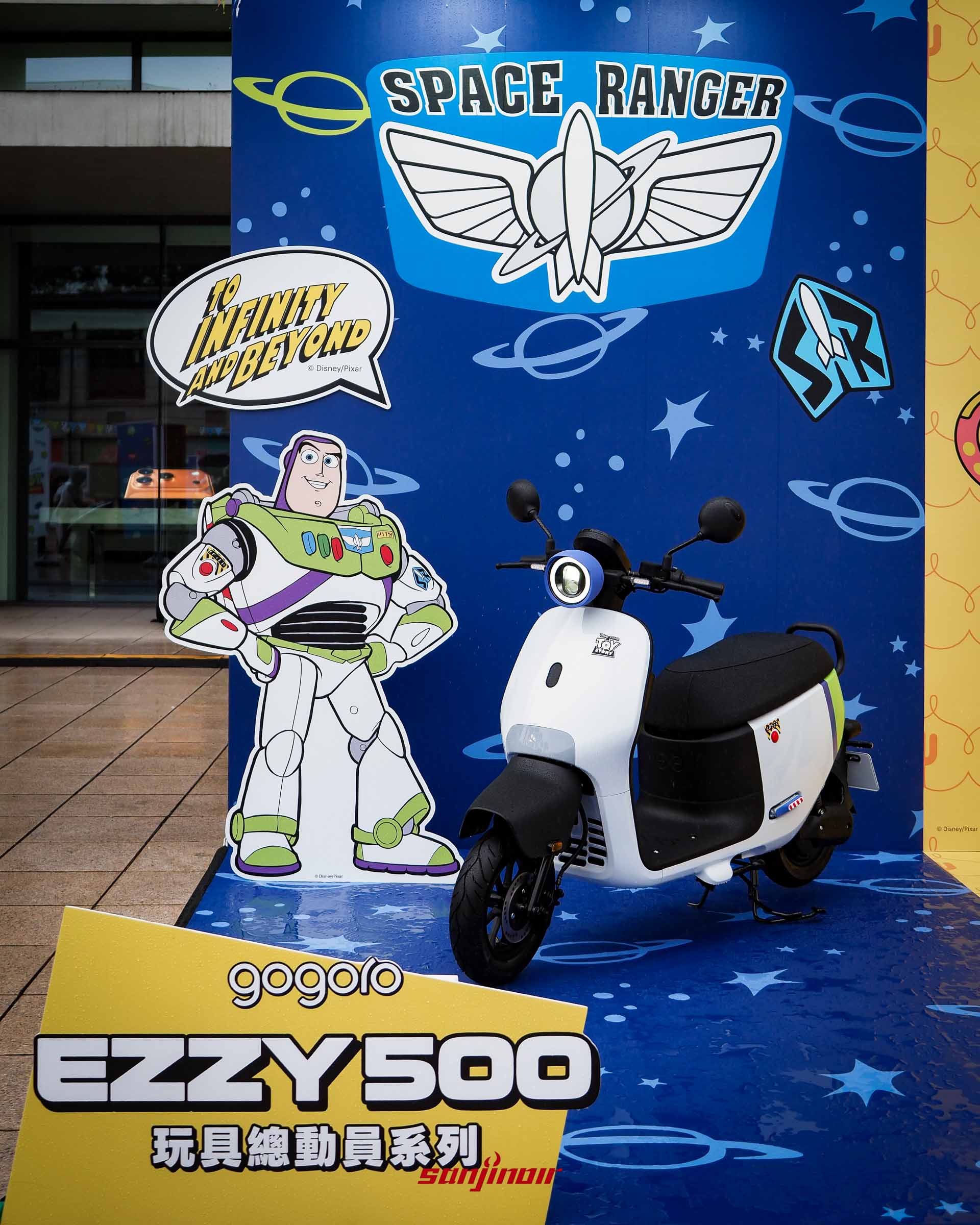 Gogoro EZZY 500浩瀚宇宙號機車與巴斯光年立牌合影，前方有Gogoro與玩具總動員聯名招牌。
