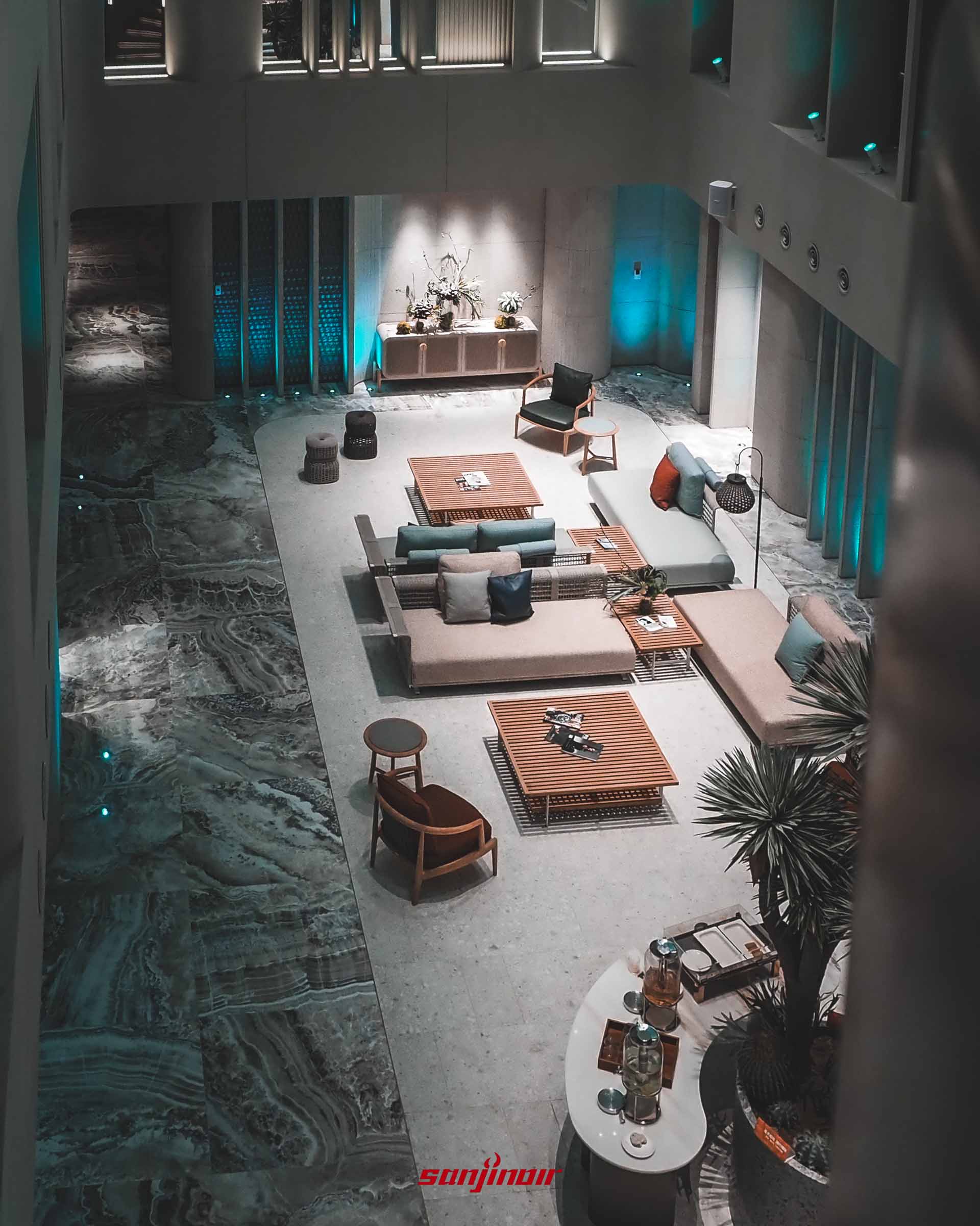 從高處俯瞰大廳,可見灰色石紋地板與多組米白色沙發。