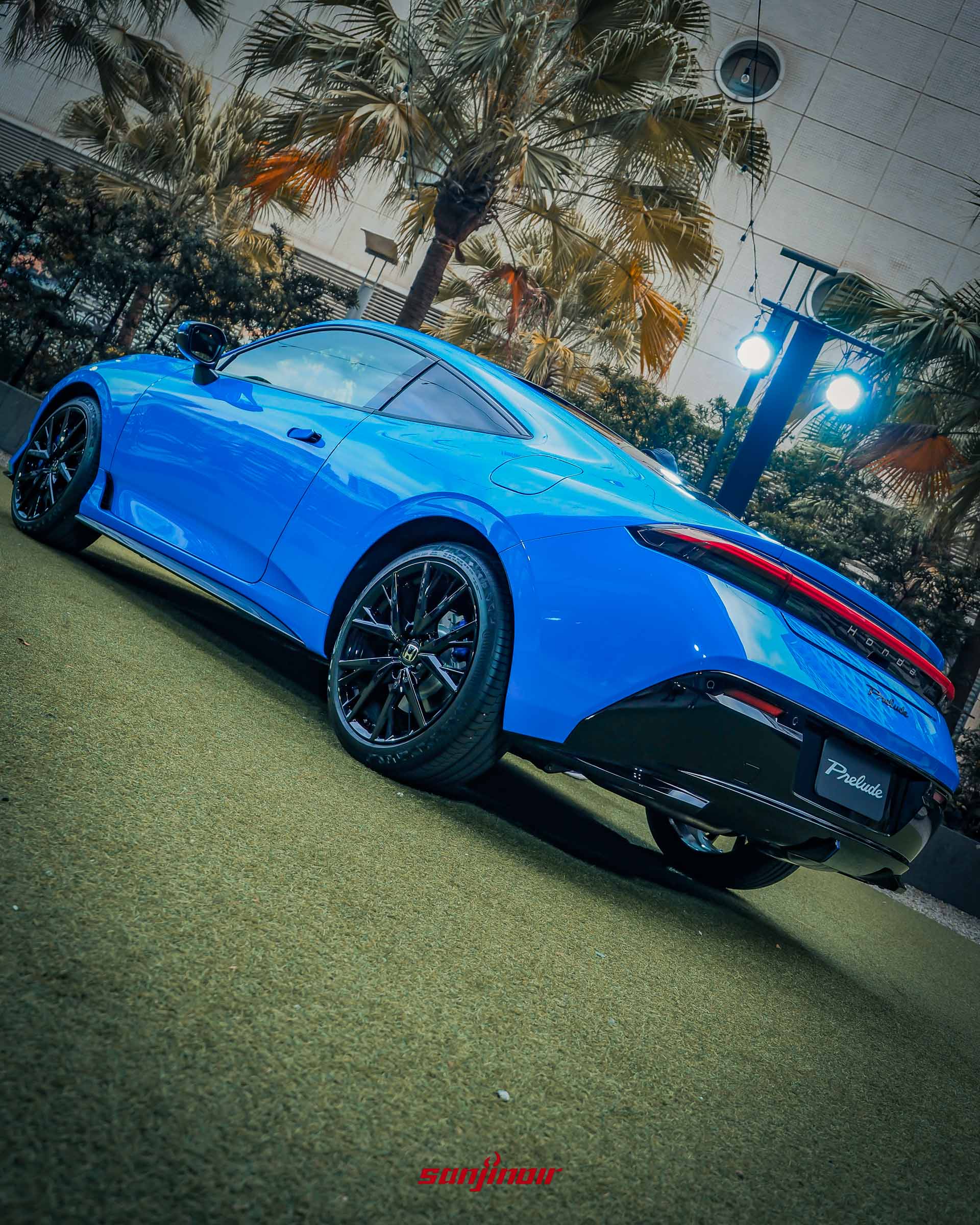 從低角度仰拍藍色Honda Prelude側面輪廓,強調其雙門跑車的流暢線條與黑色輪框。
