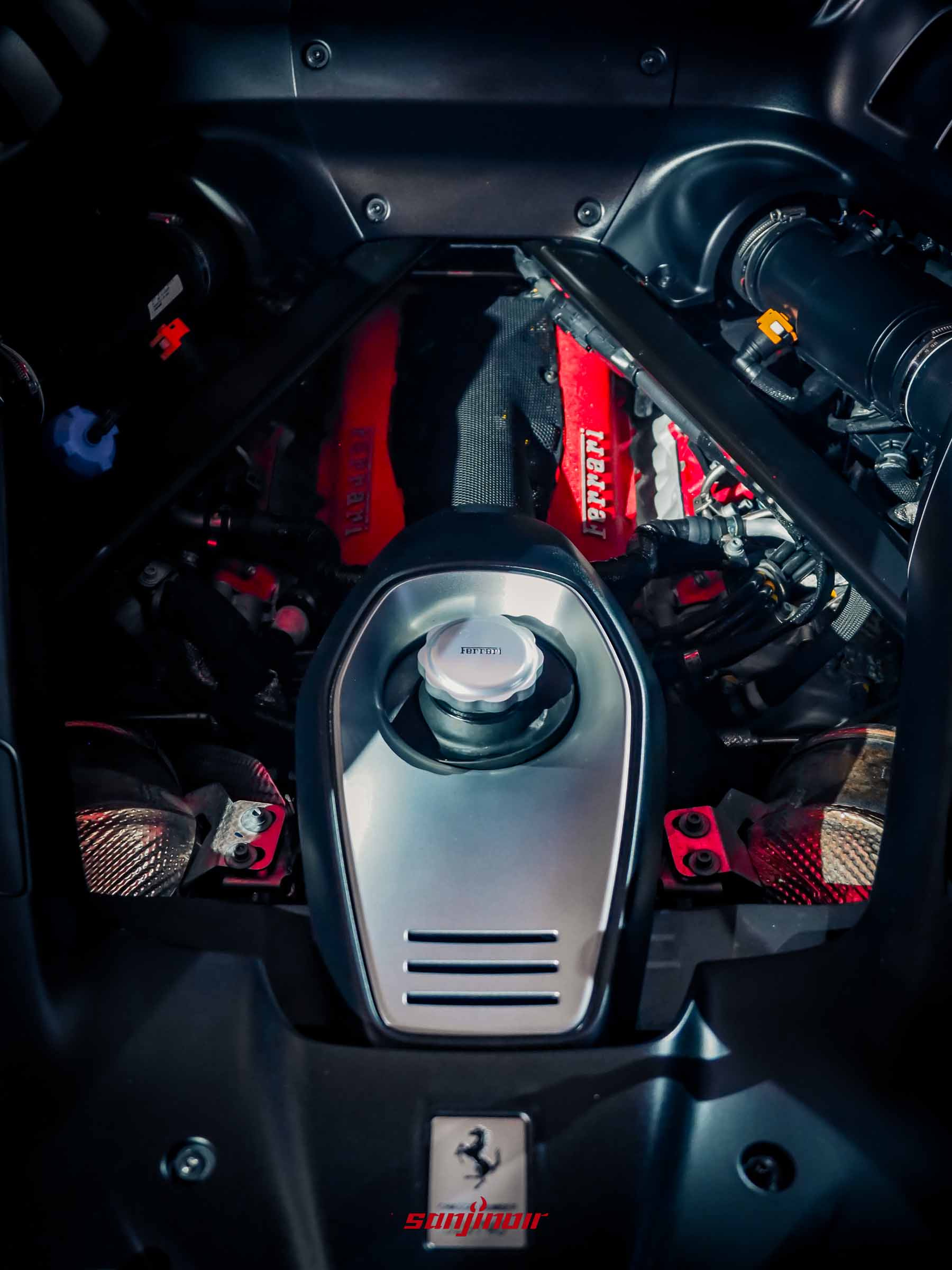 F154FC V8 雙渦輪增壓引擎位於 Ferrari 849 Testarossa 橙色車款的後中置位置。引擎凸輪軸蓋被塗成鮮紅色 (紅頭)。銀色金屬製的 Ferrari 「躍馬」標誌位於照片底部。