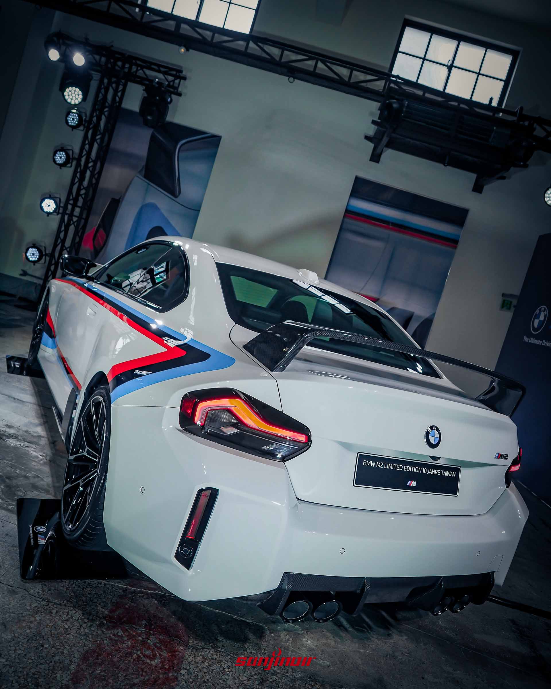 白色BMW M2特仕版左後方45度角外觀照，展示厚實的後保桿設計、雙邊四出排氣尾管與大型碳纖維擾流尾翼。