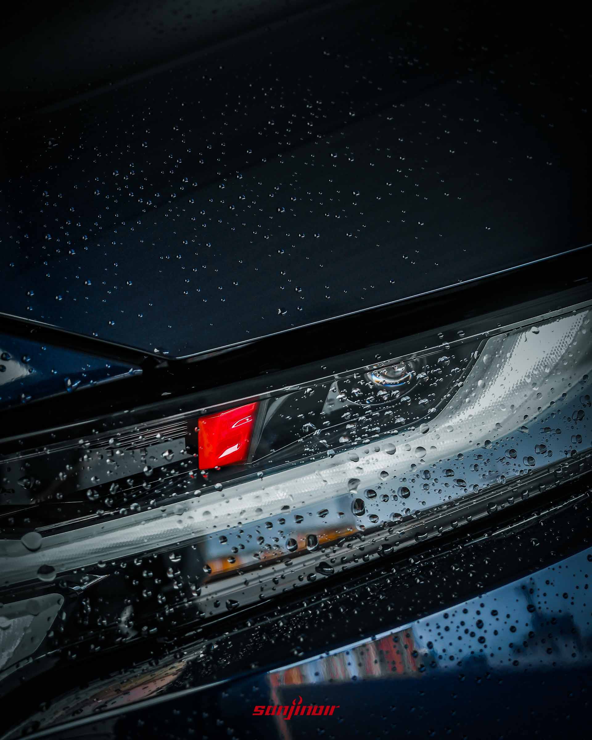 MAZDA CX-5車頭燈特寫,引擎蓋上佈滿水珠,燈具內有紅色反光細節。