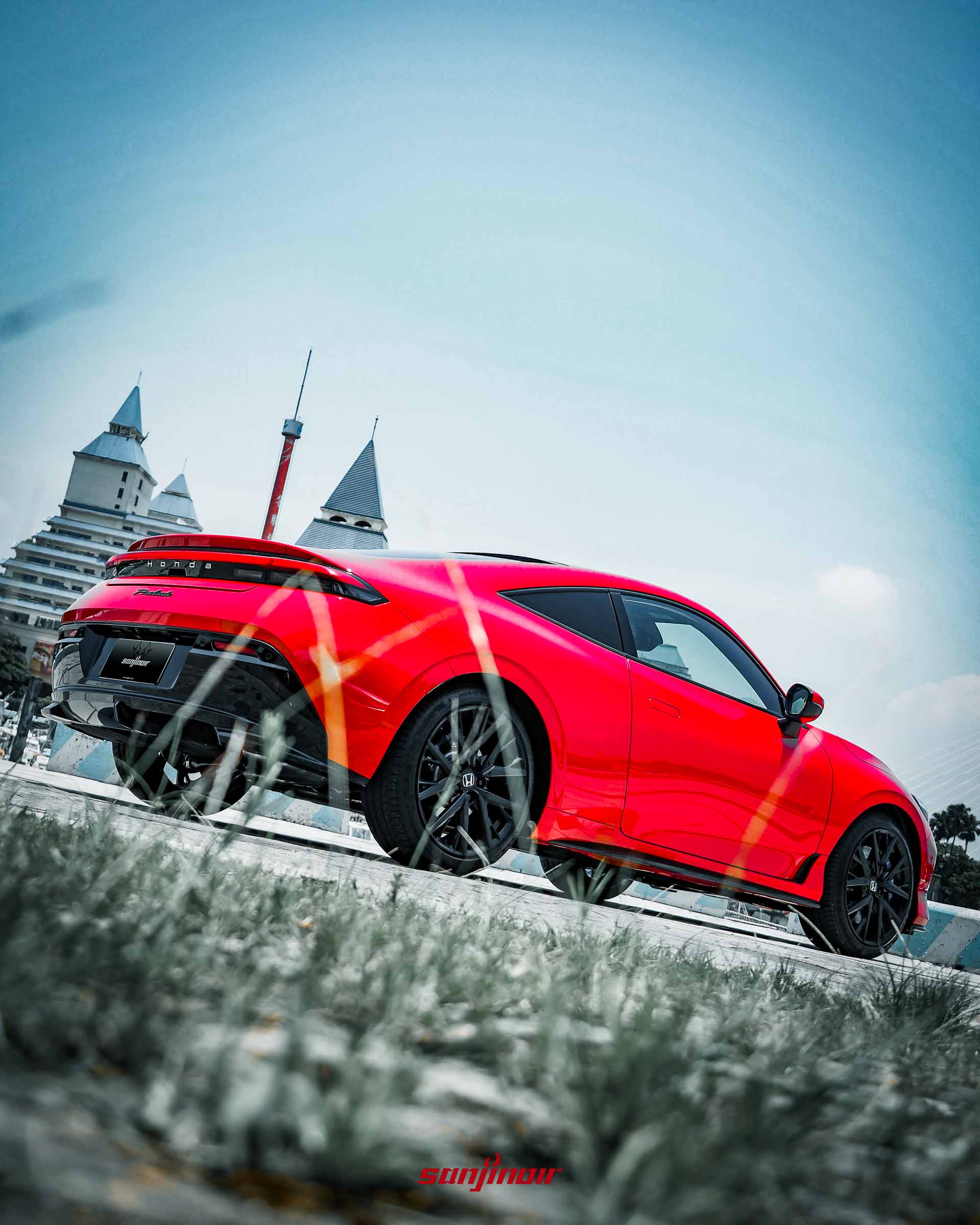 從低角度拍攝的紅色HONDA Prelude右後方視角,展示傾斜的車頂線條、貫穿式尾燈與黑色下擾流。