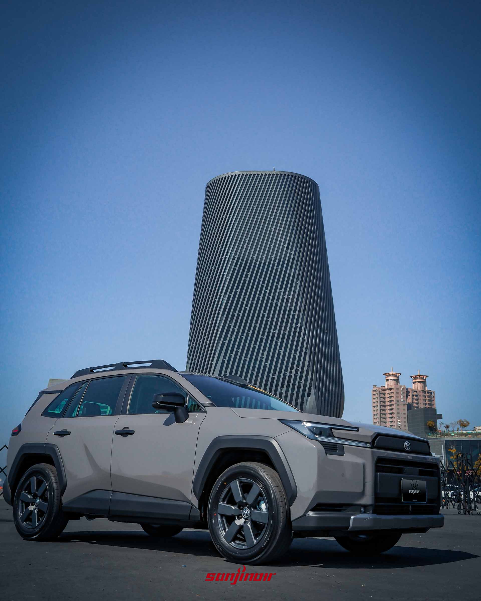 RAV4 Adventure 車側視角，背景為港口建築，展示車身線條與輪廓。