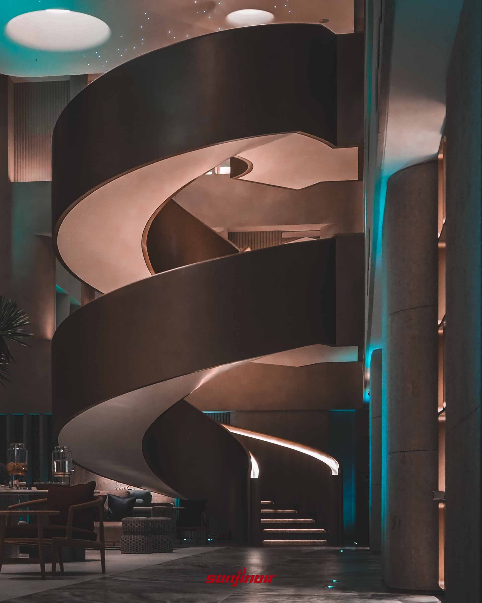 大廳巨大的金屬螺旋樓梯,階梯兩側設有柔和燈光照明。