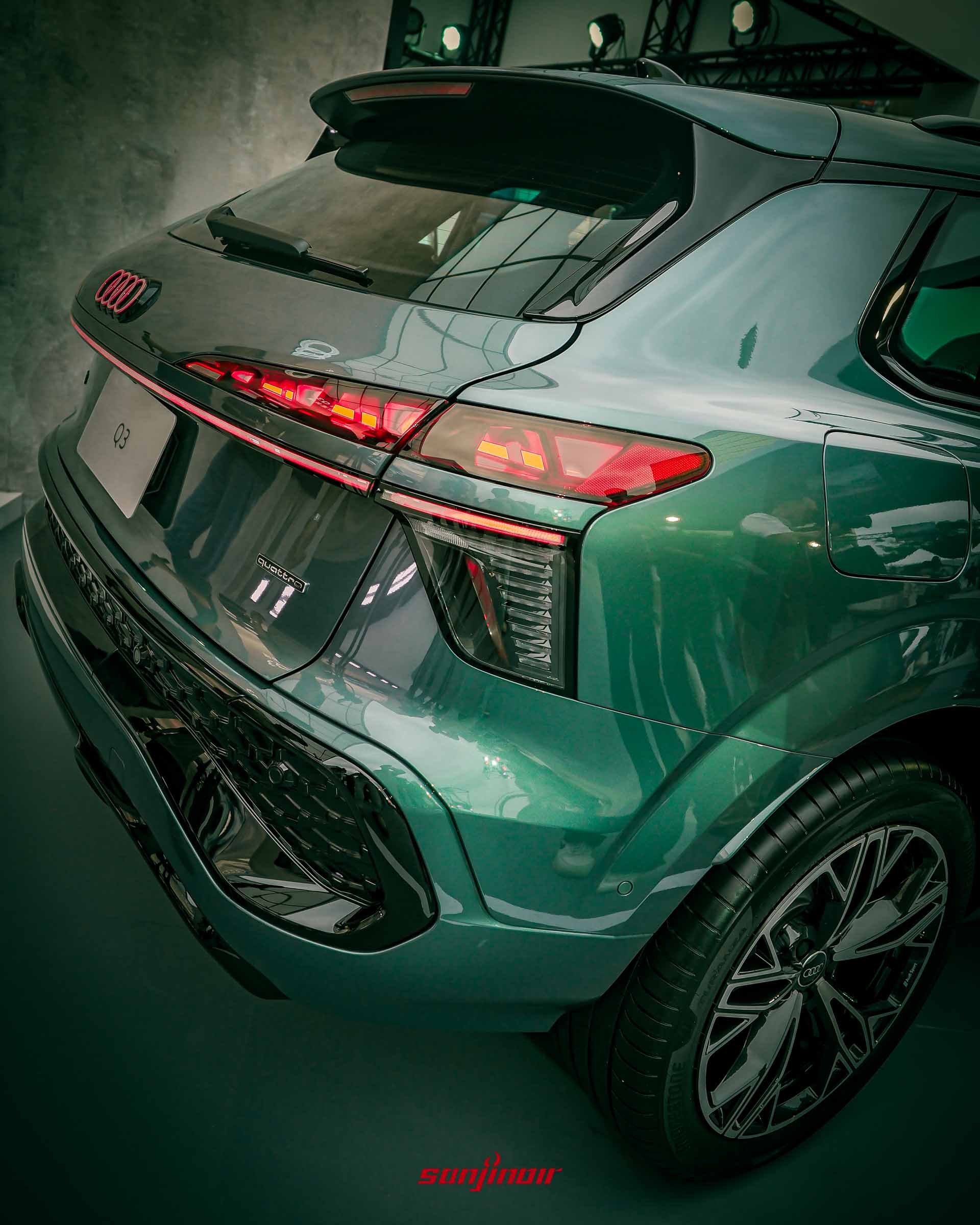 綠色Audi Q3車尾特寫展示點亮的紅色數位OLED尾燈與quattro銘牌。