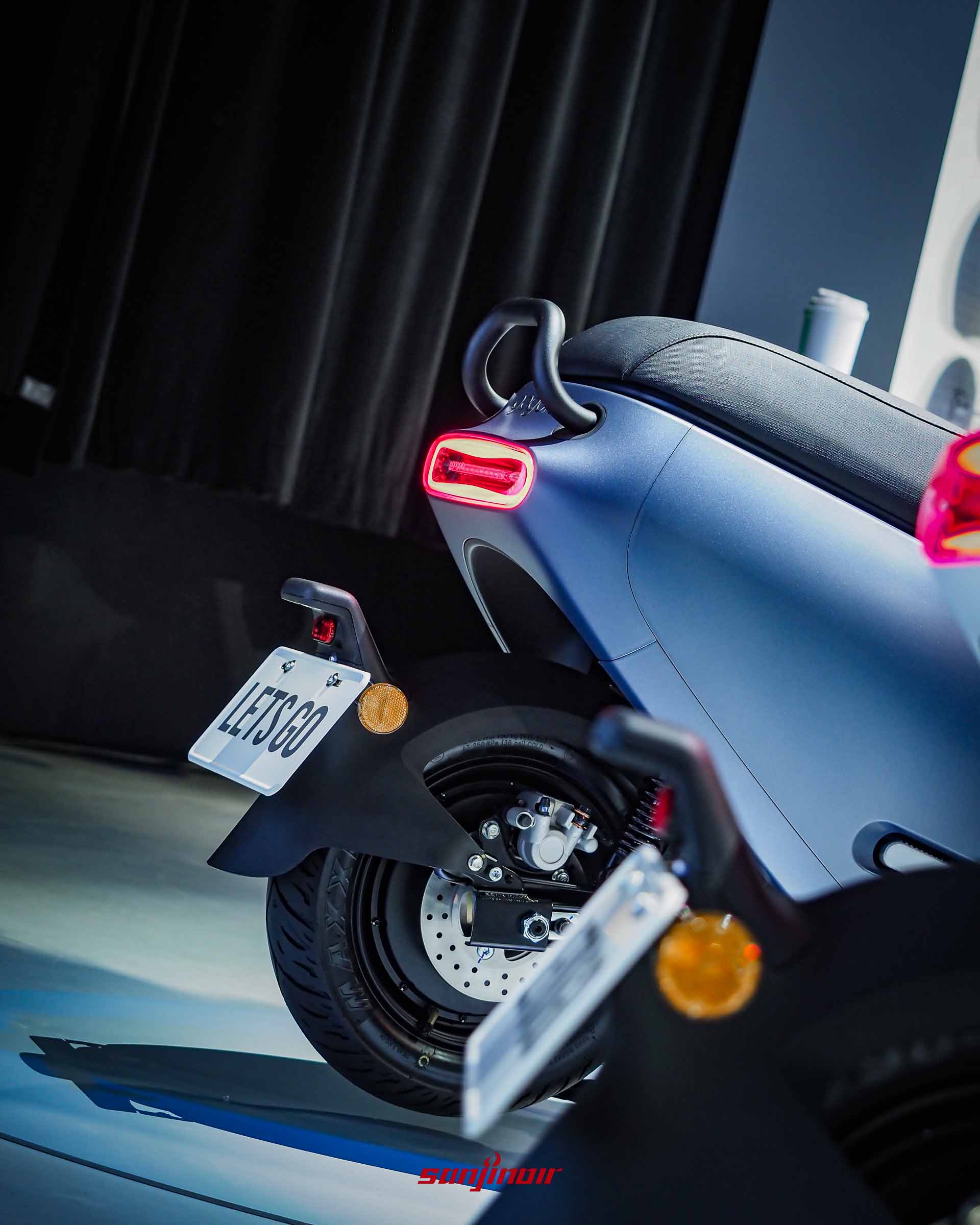 Gogoro Luna車尾特寫照片，展示紅色發光的月弧型一體式尾燈、後扶手及下方牌照框配置。