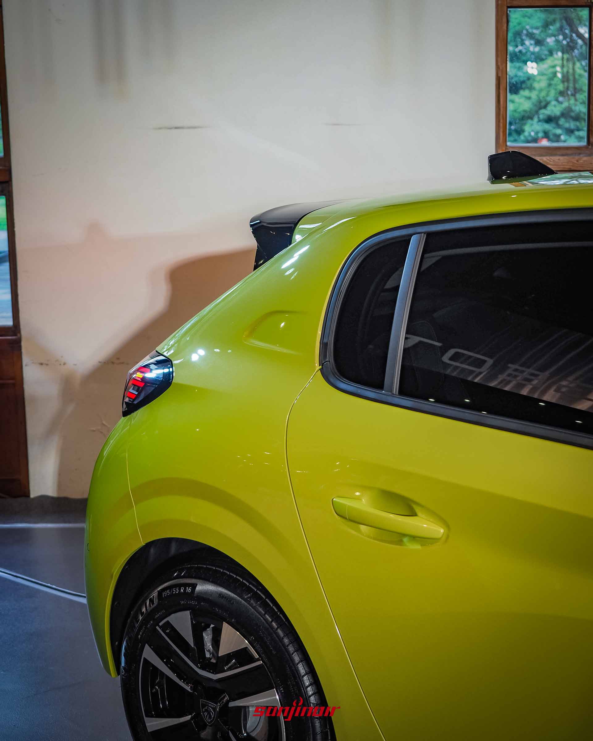 特寫黃色PEUGEOT 208 P2 Hybrid的左後車側線條,包含後車門把手、C柱造型、亮黑色輪拱邊條與部分尾燈設計。