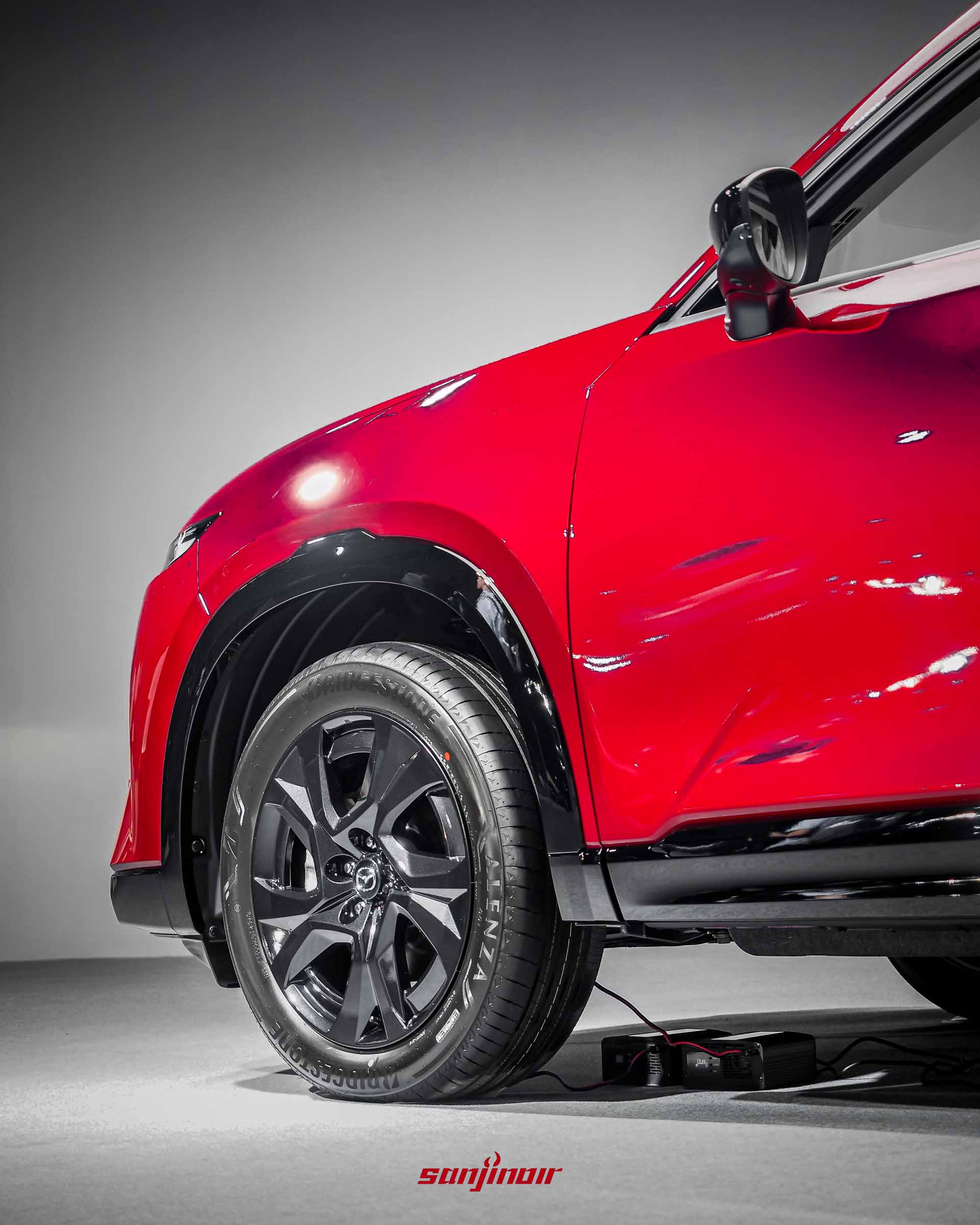 紅色MAZDA CX-5前輪特寫，展示黑色輪拱護板、19吋黑色輪圈及普利司通輪胎。