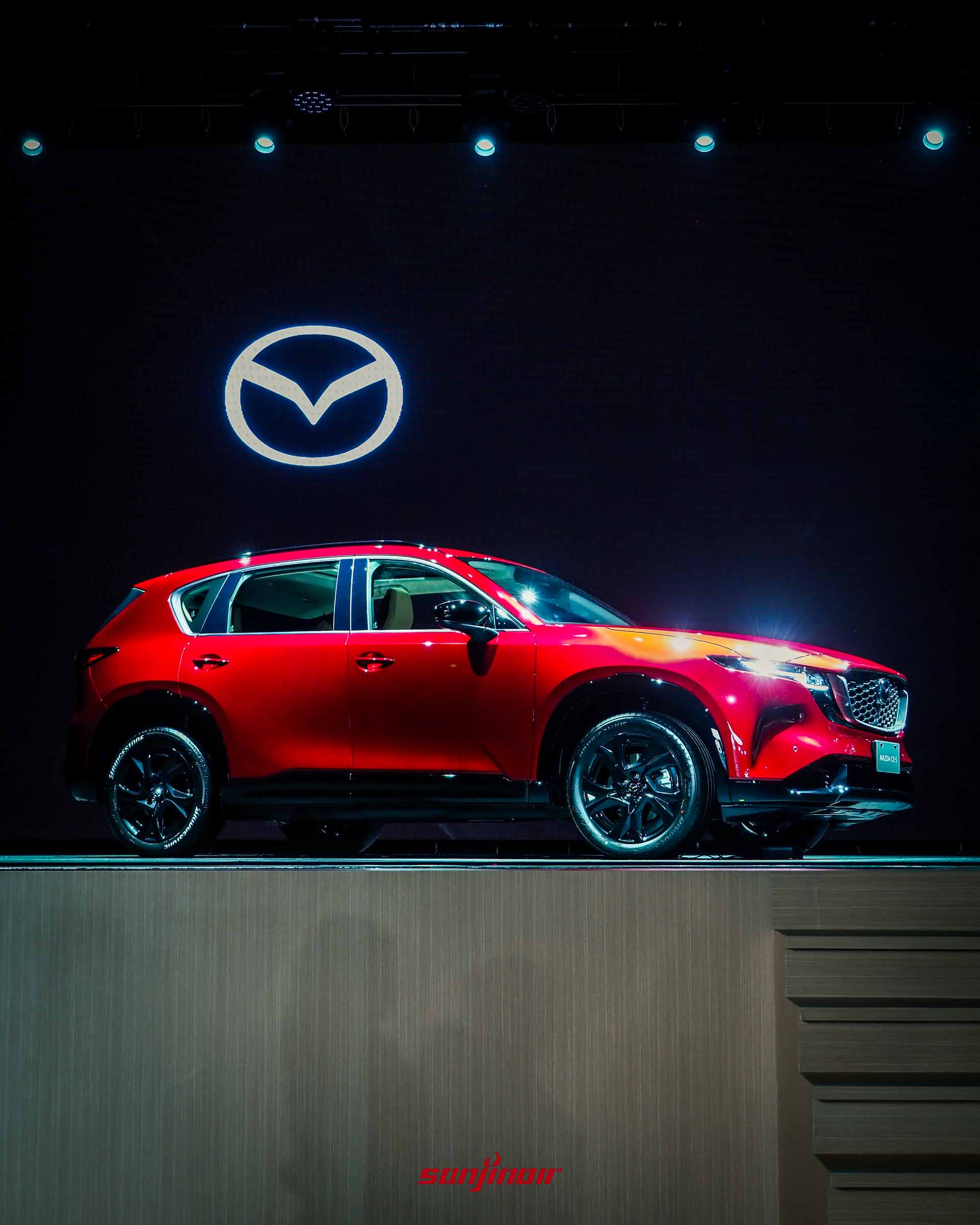 全新MAZDA CX-5紅色車款的車身側面視角,展現修長車身、流線車頂與大尺寸黑色鋁圈。