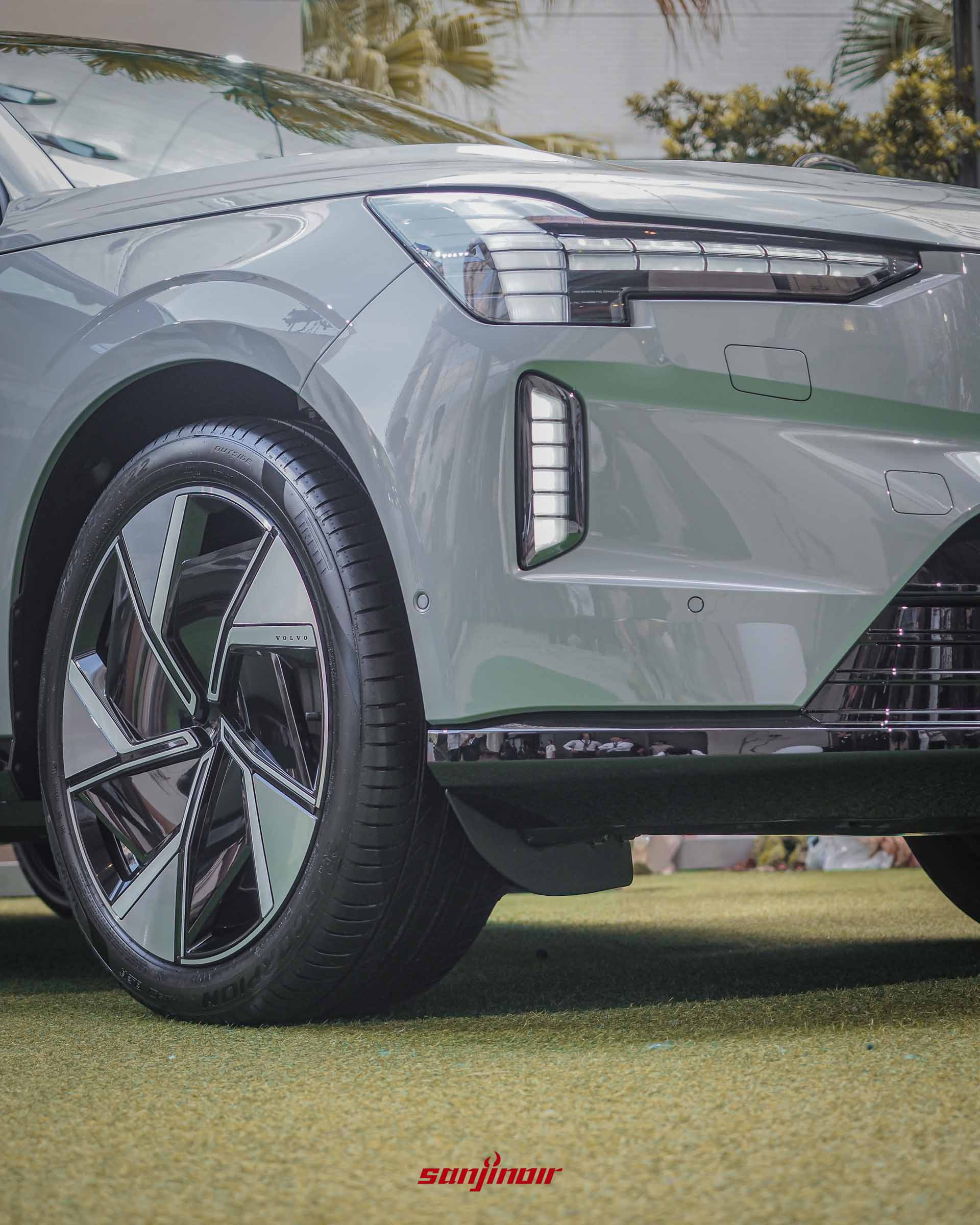 Volvo EX90的右前輪與車頭特寫,清楚呈現雙色切削空氣力學輪圈的幾何造型與前保險桿兩側的燈具細節。
