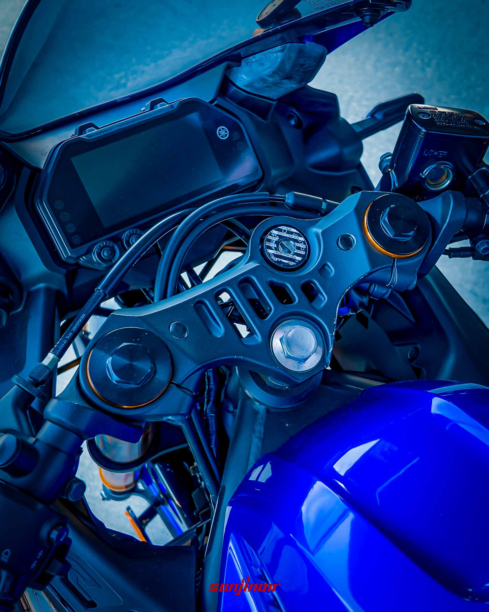 Yamaha YZF-R3的騎士視角,畫面包含藍色油箱、分離式把手、TFT儀表板與鏤空設計的上三角台。