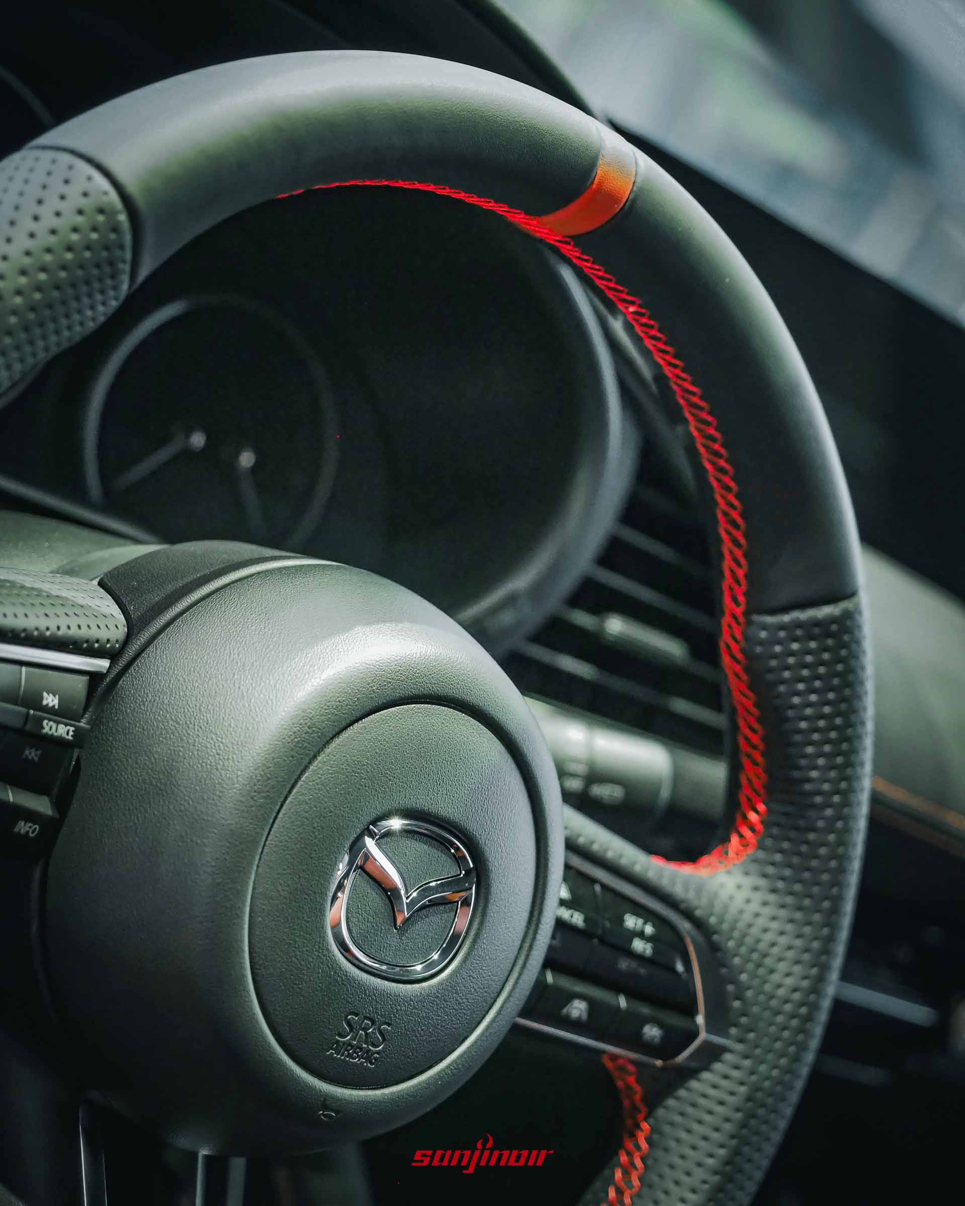 安裝於 MAZDA 車內的 AutoExe NAPPA 運動化平底方向盤特寫，展現細膩防滑沖孔真皮與紅色縫線質感。
