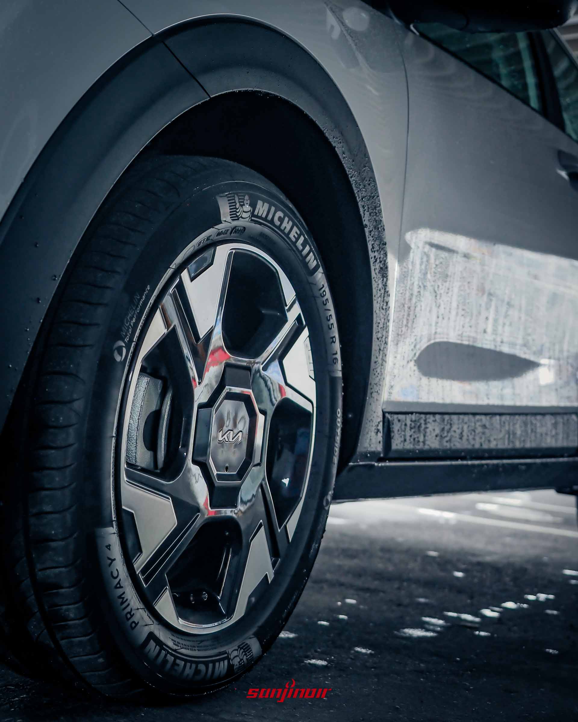 2026 Kia Stonic配備的16吋幾何造型雙色鋁圈特寫,搭配Michelin Primacy 4輪胎,車身帶有雨水。