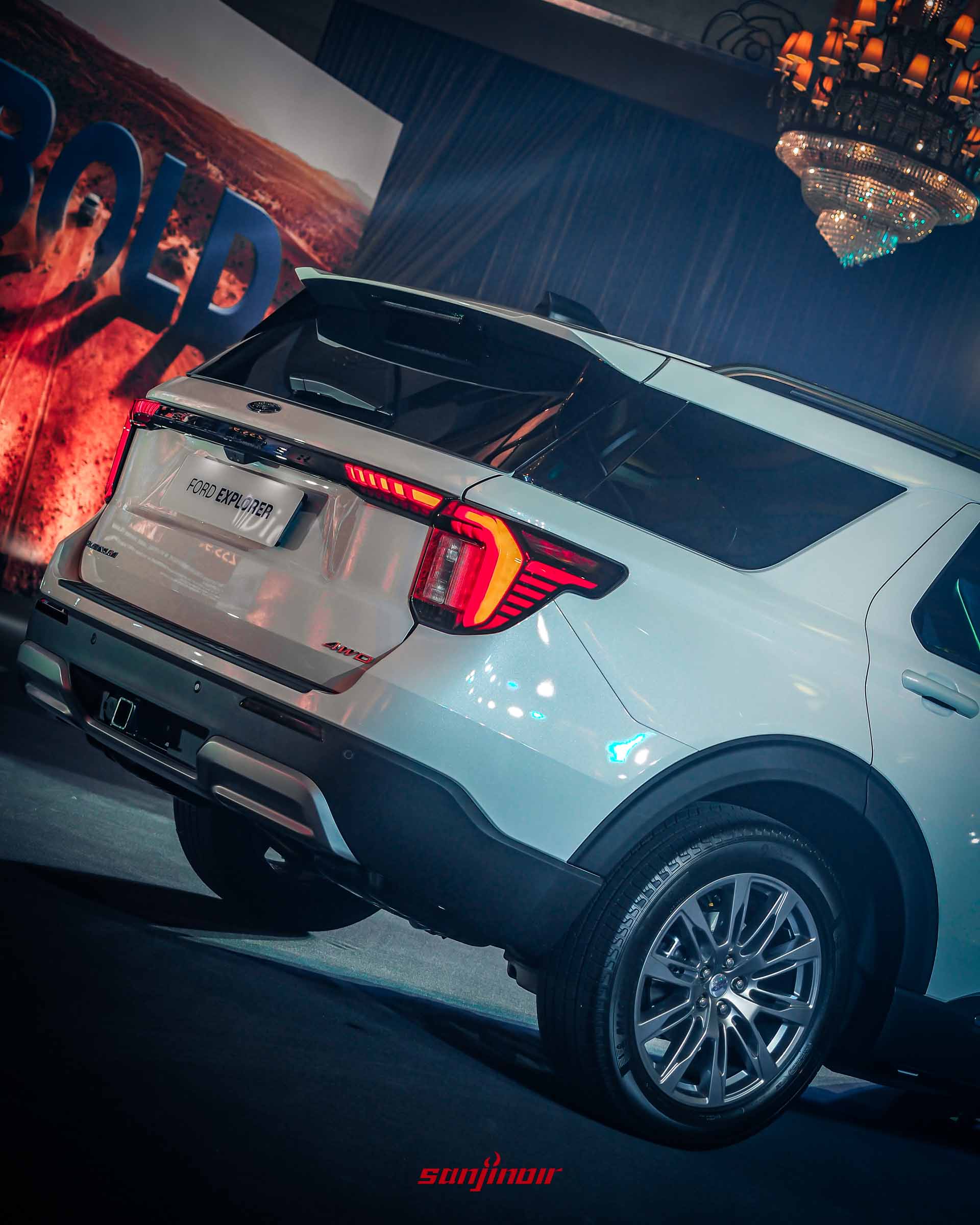 發表會舞台上一輛白色Ford Explorer後部的仰視近景，聚焦於左側尾燈和車尾「FORD EXPLORER」及「AWD」標誌。