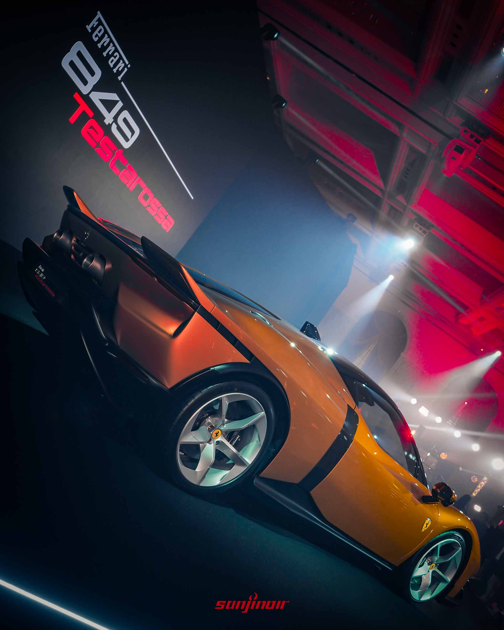 2026 Ferrari 849 Testarossa 橙色 Berlinetta 的後側視角，展現其後輪、尾燈與創新的雙尾翼結構，後者源自 1970 年代的賽車設計，為提升空氣動力學效率而設計。