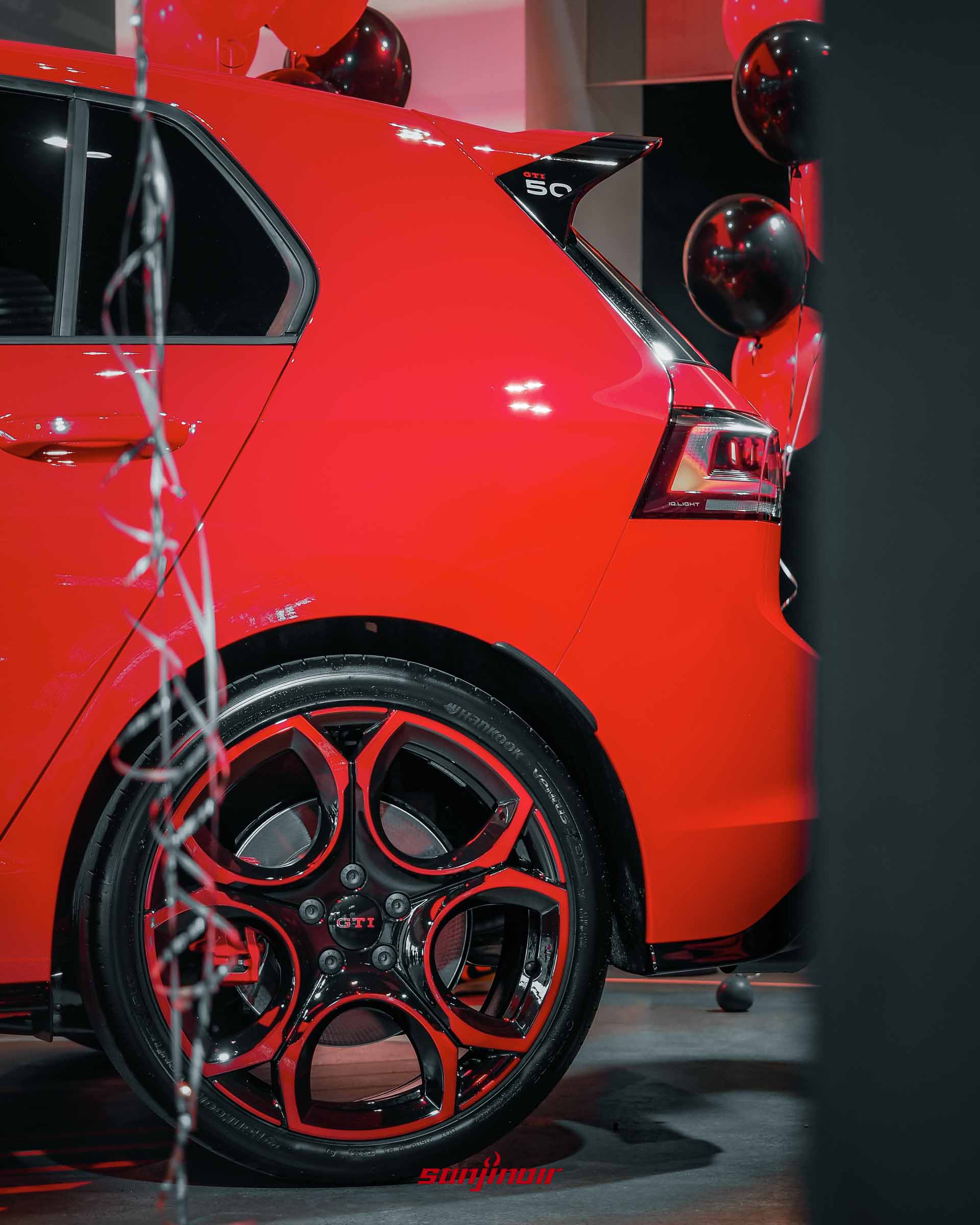 特寫Golf GTI EDITION 50的19吋輪圈、紅色煞車卡鉗，以及車頂尾翼側面的GTI 50專屬白色徽飾。