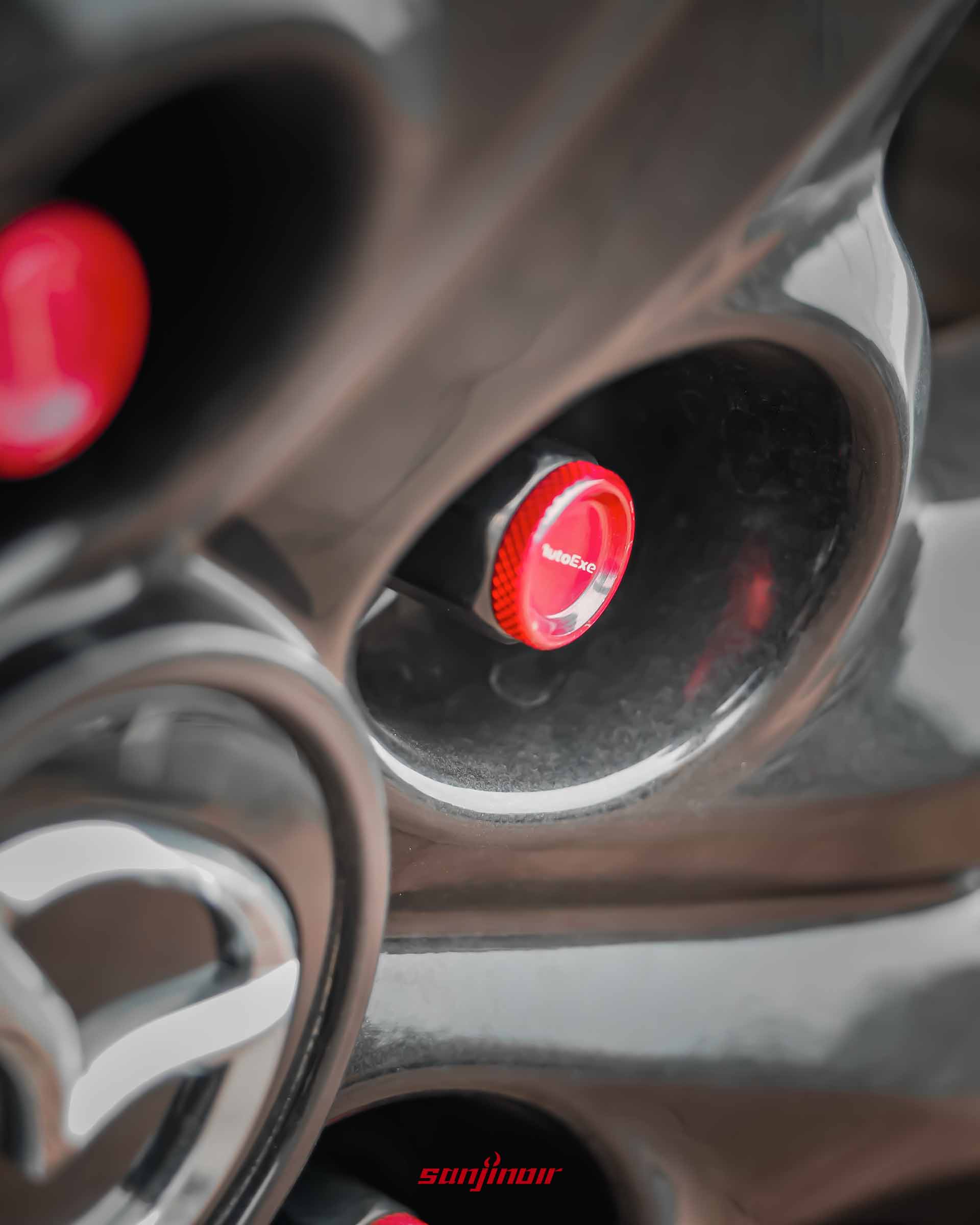 MAZDA CX-30黑色輪框特寫,中央配有一顆刻有AutoExe字樣的紅色高剛性螺帽。