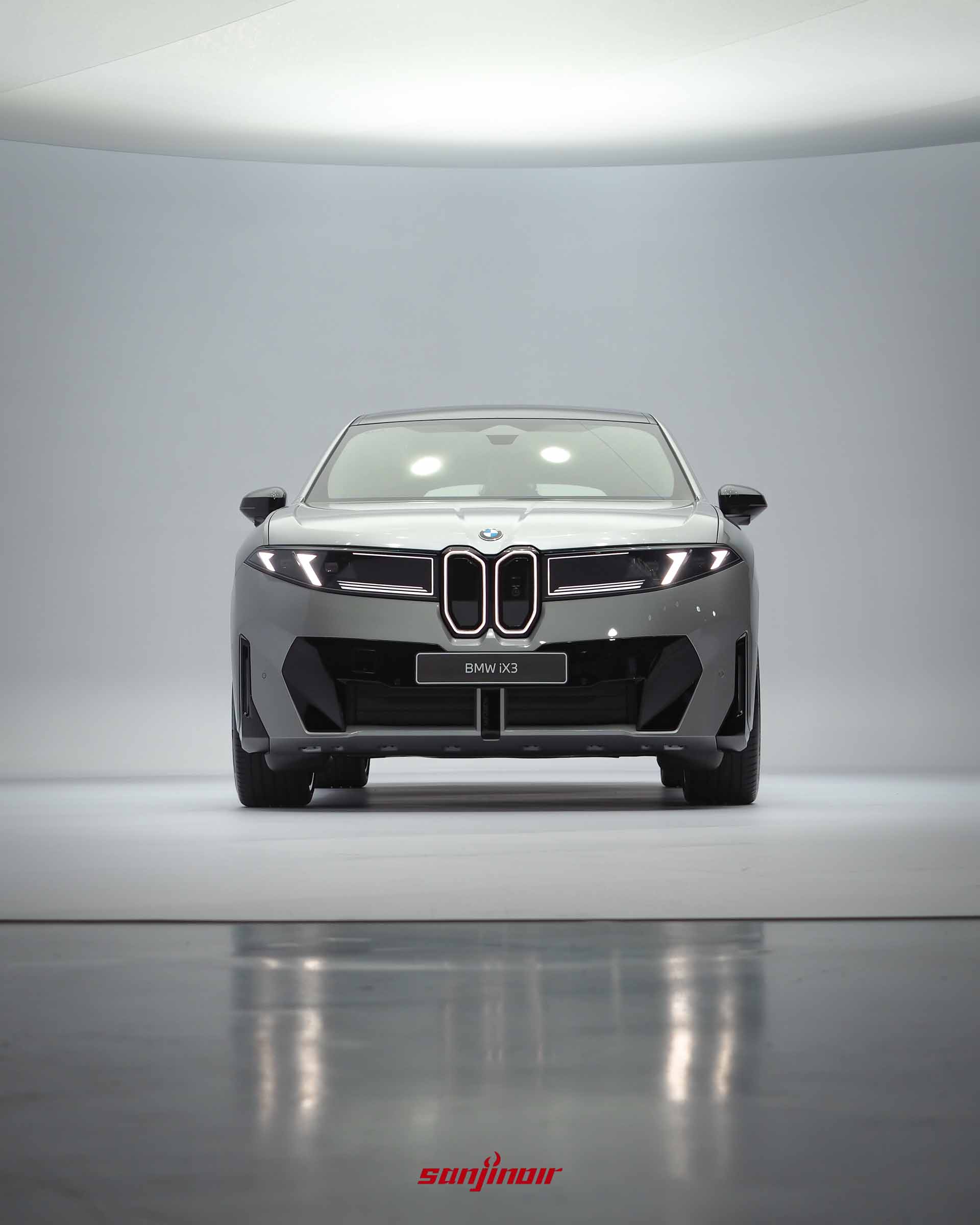 BMW iX3的正車頭特寫,垂直細長的水箱護罩帶有發光外框,兩側為四眼式垂直日行燈。