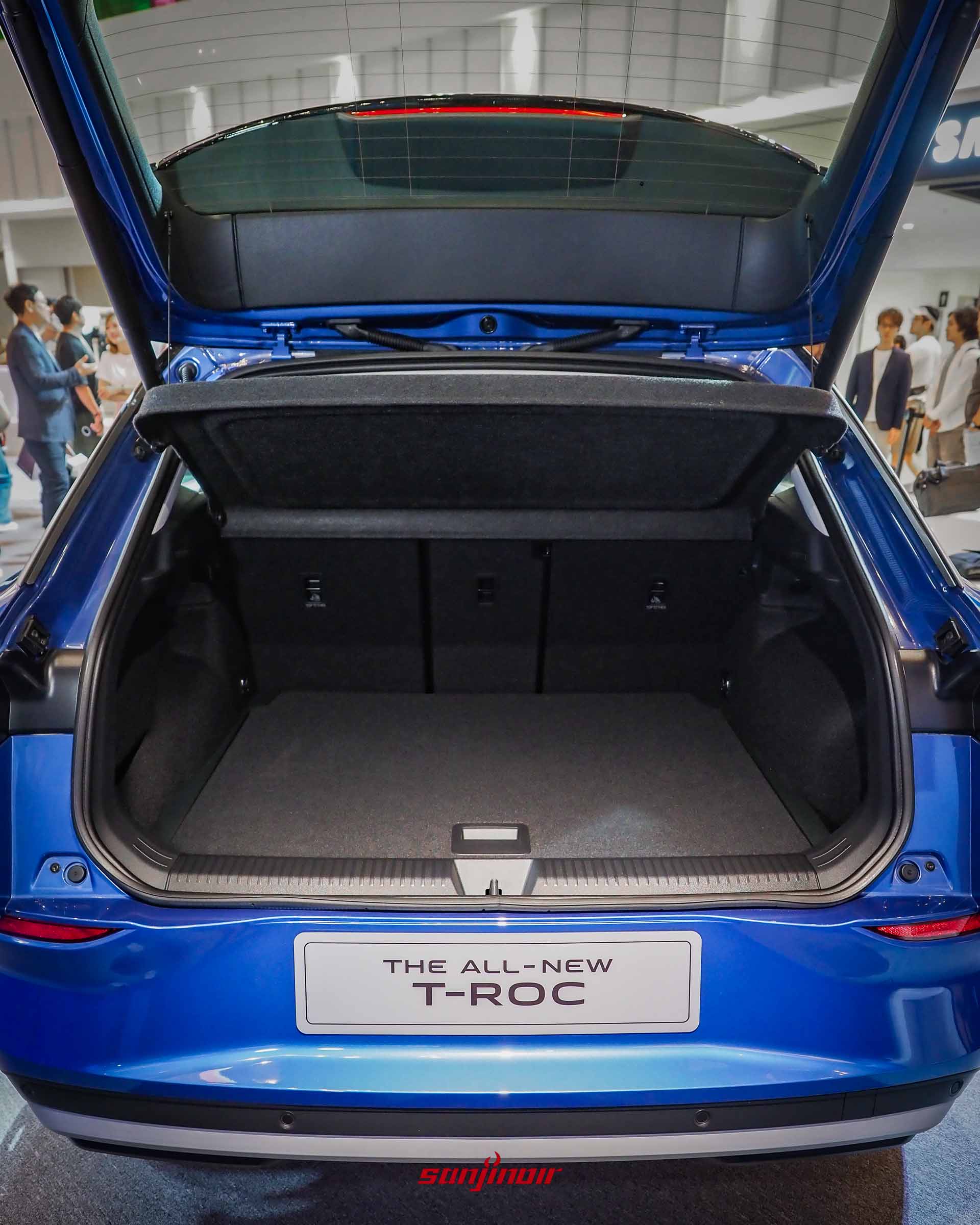 藍色Volkswagen T-Roc尾門完全開啟的正後方視角,展示平整且寬敞的空行李廂內部空間與障板。