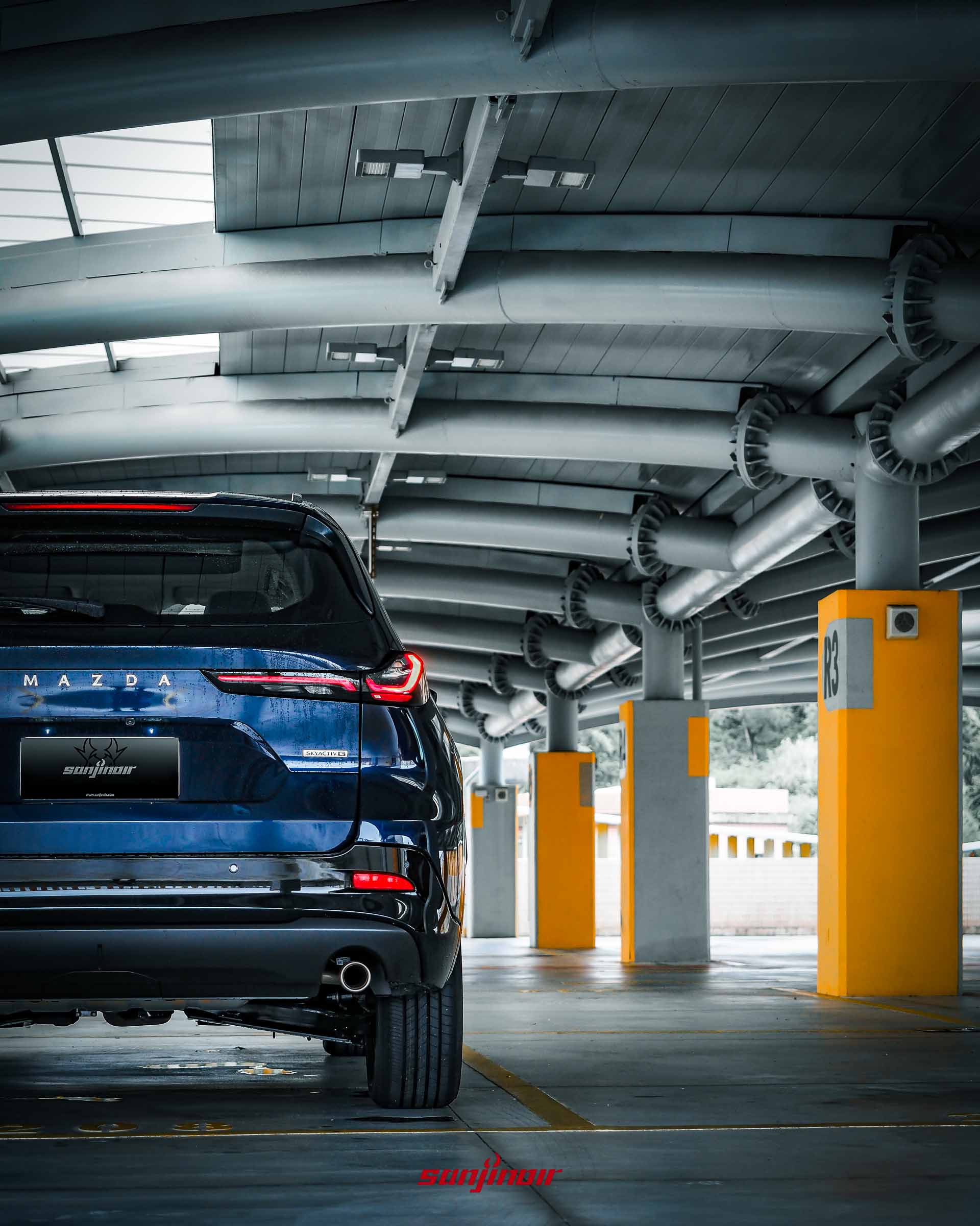 MAZDA CX-5停放於停車場的車尾正後方面貌,展現尾燈與雙出排氣管設計。