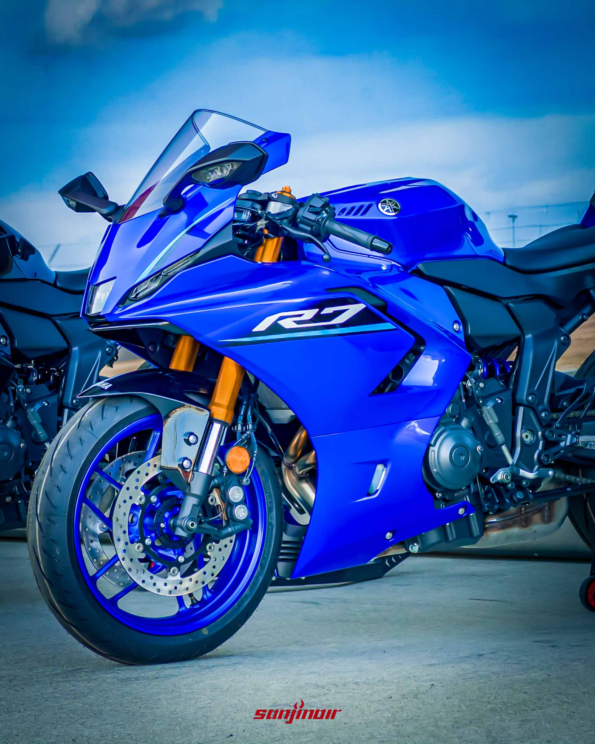 藍色Yamaha YZF-R7靜態側拍,展示其修長的車身比例、金色倒立式前叉與流線型的整流罩設計。