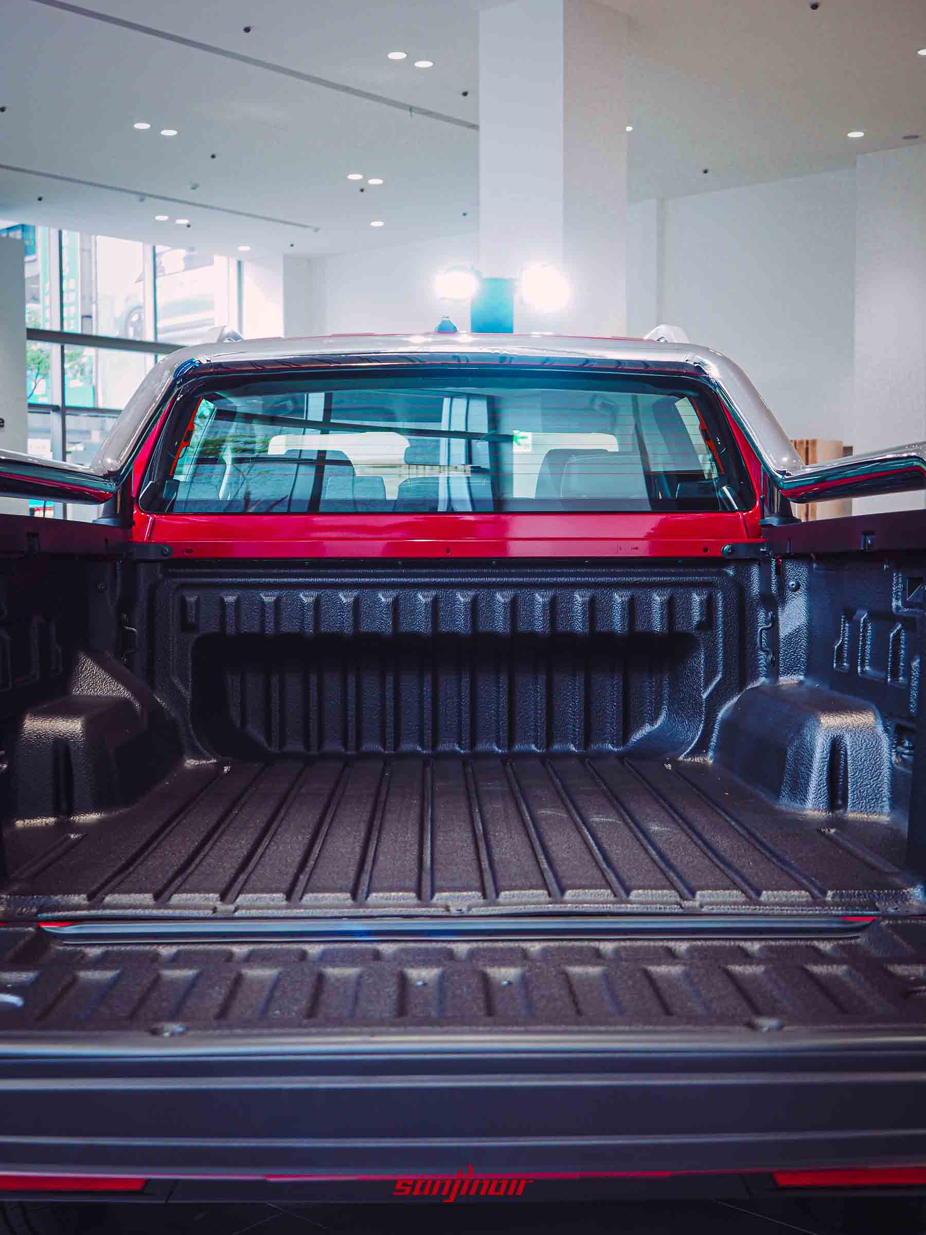 由車尾向車頭望去的貨斗內部特寫，內部鋪設黑色防刮抗磨損材質，並有鍍鉻防護架。