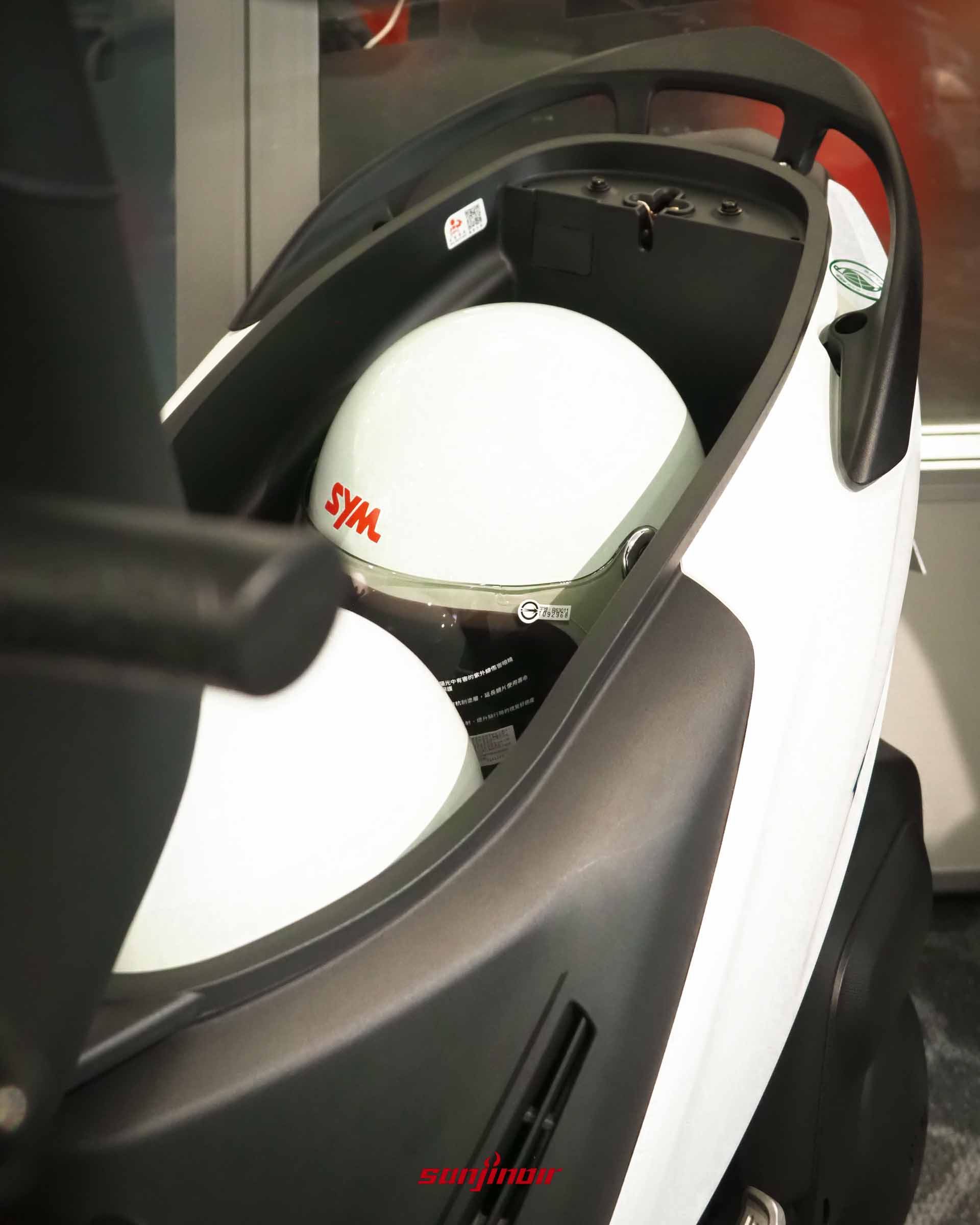 2026 SYM Duke迪爵125打開坐墊後的37.5L置物廂空間，內部放置了一頂SYM白色安全帽且仍有餘裕。