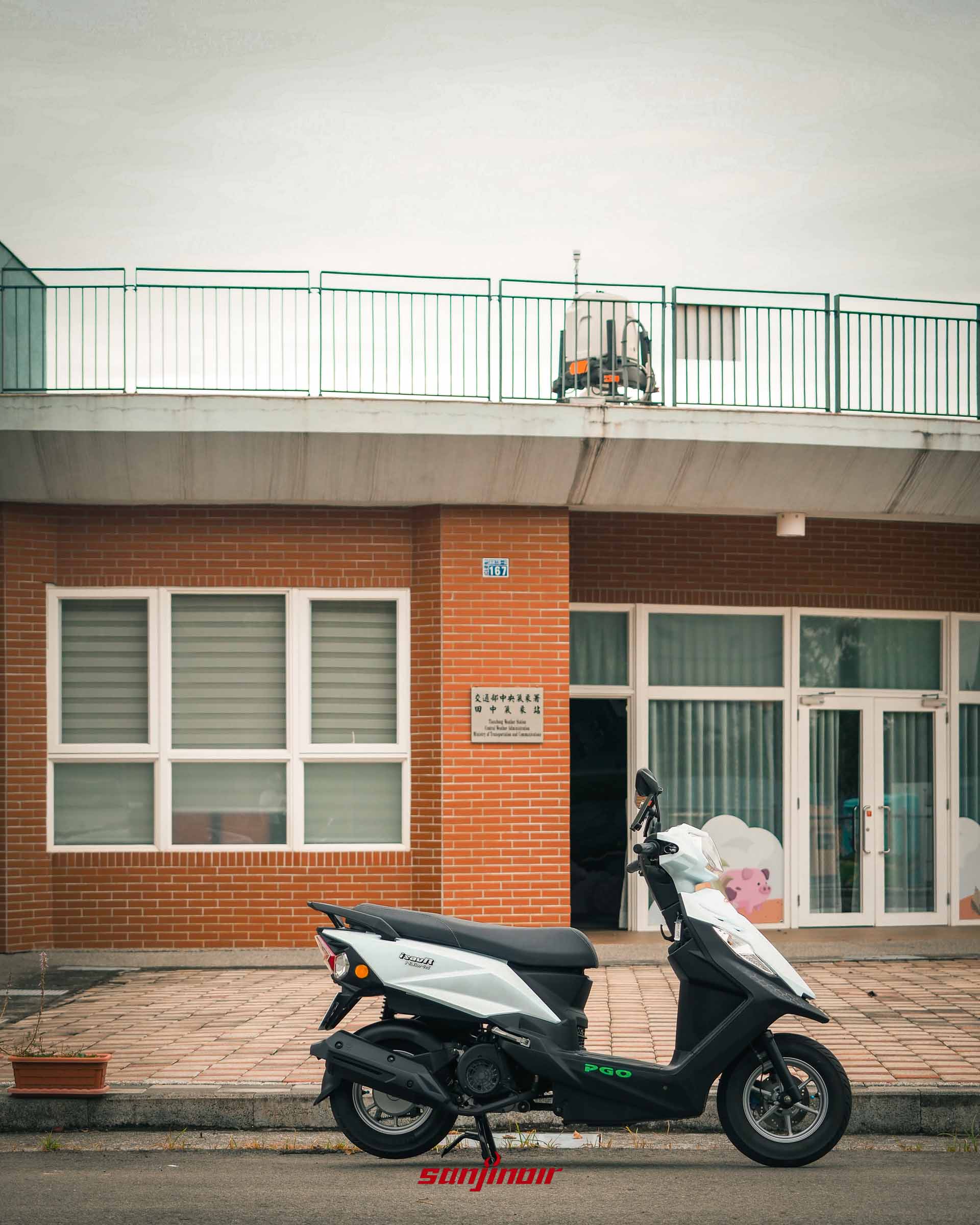 白色PGO isavR威力125停放在紅磚外牆的交通部中央氣象署田中氣象站前方。