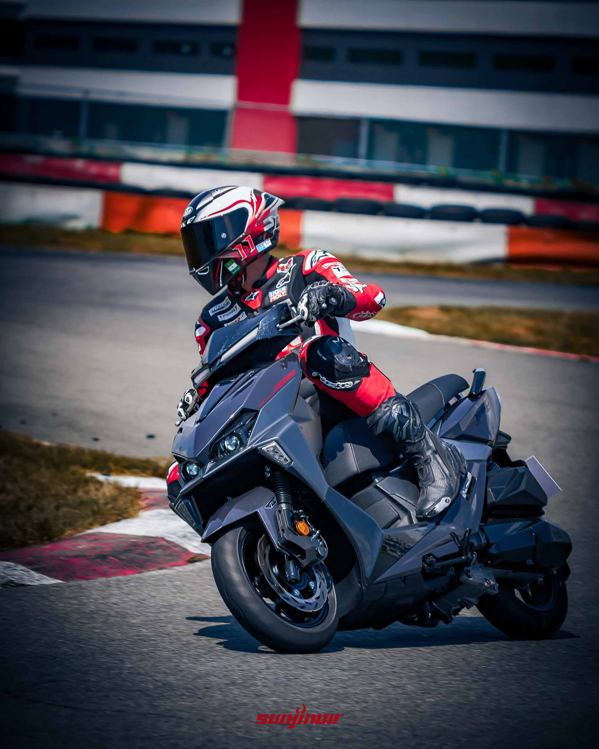 賽車手騎乘SYM Jet SL+以右傾角過彎，膝蓋貼近路面的極限操駕特寫。