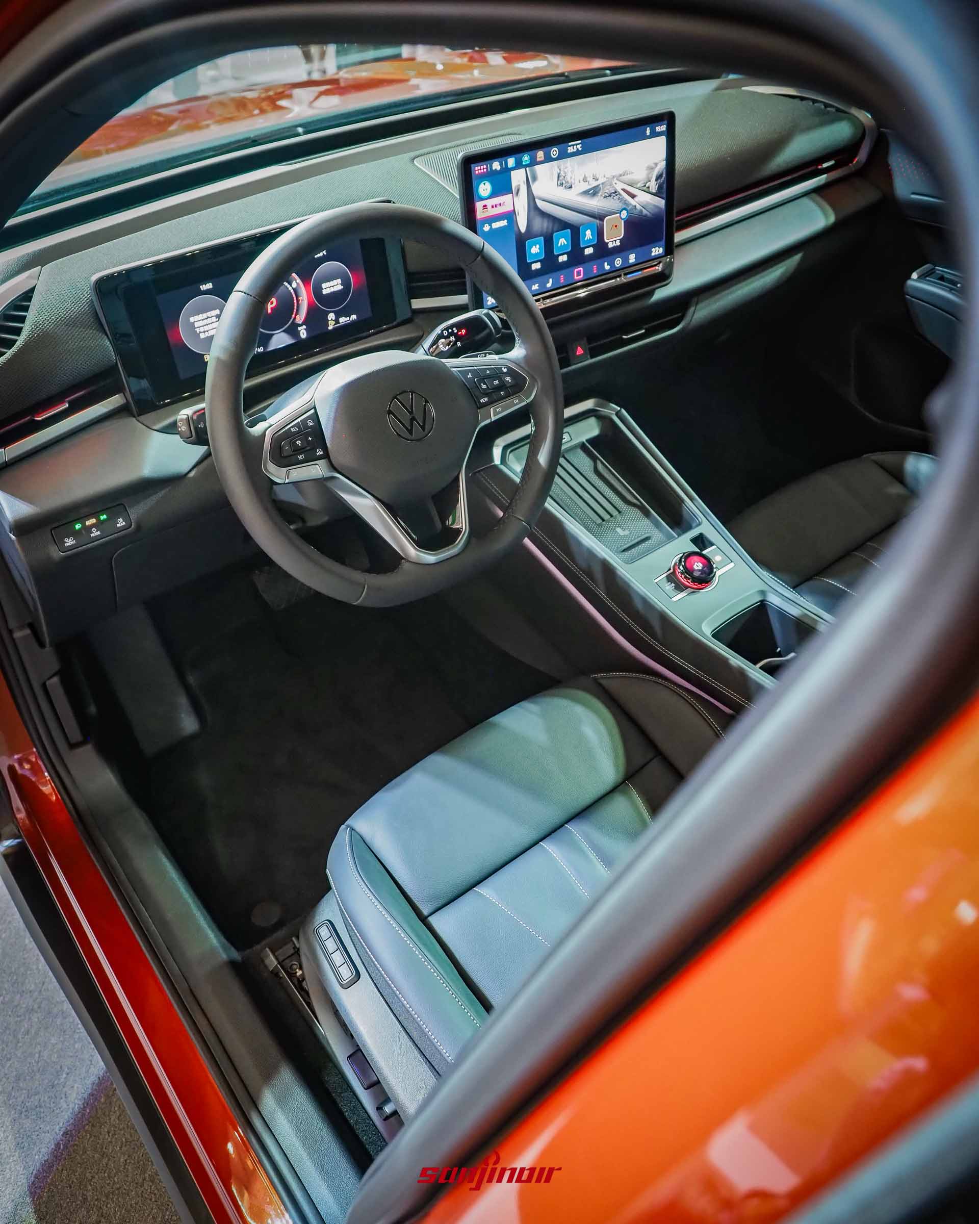 從副駕駛座車門外向內拍攝的Volkswagen T-Roc內裝,顯示出方向盤、數位儀表板、大型中控觸控螢幕以及皮質座椅。