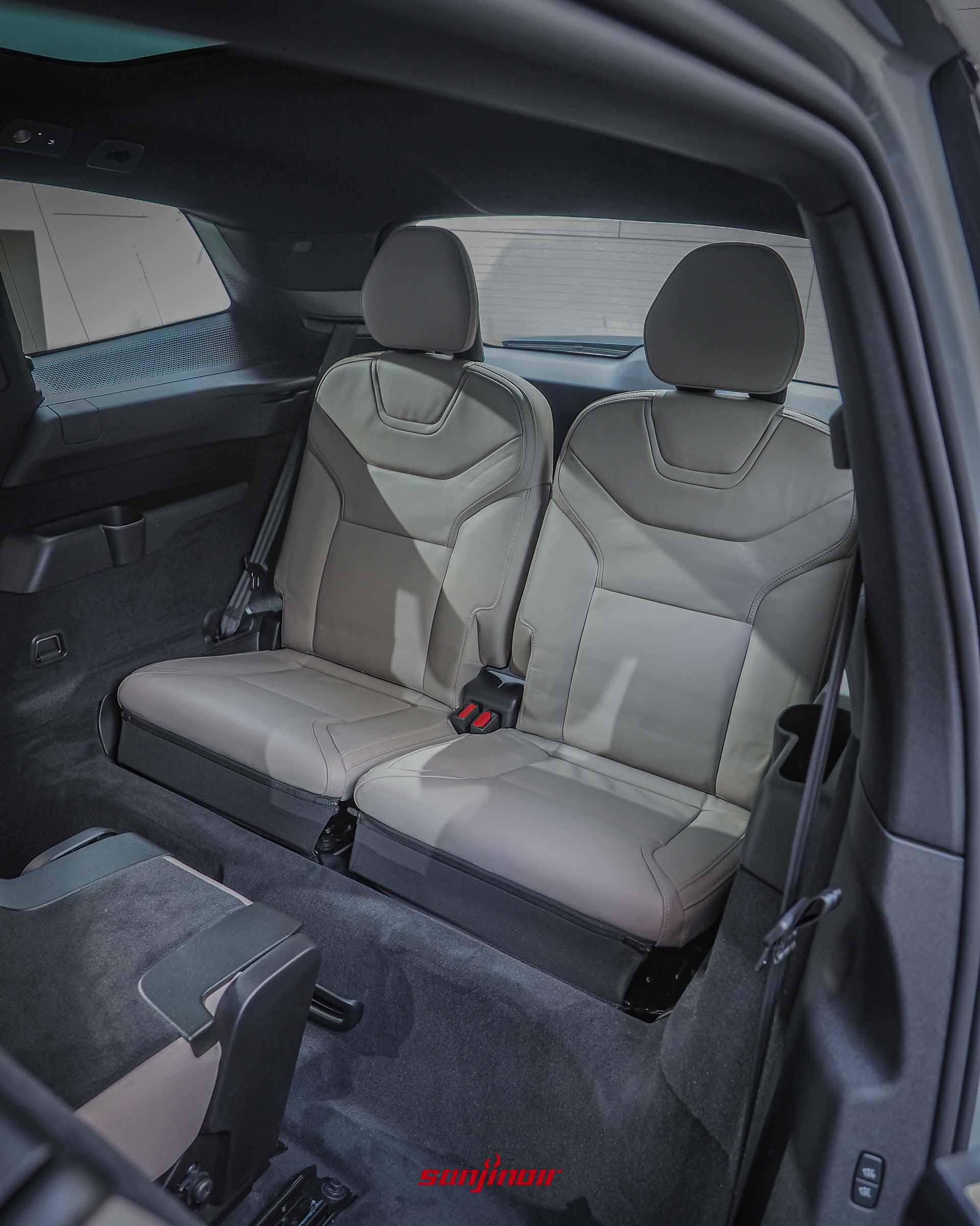 Volvo EX90的第三排座椅特寫,兩張淺米色皮質座椅立起,前方連接平整的車廂底板,展現後排空間配置。