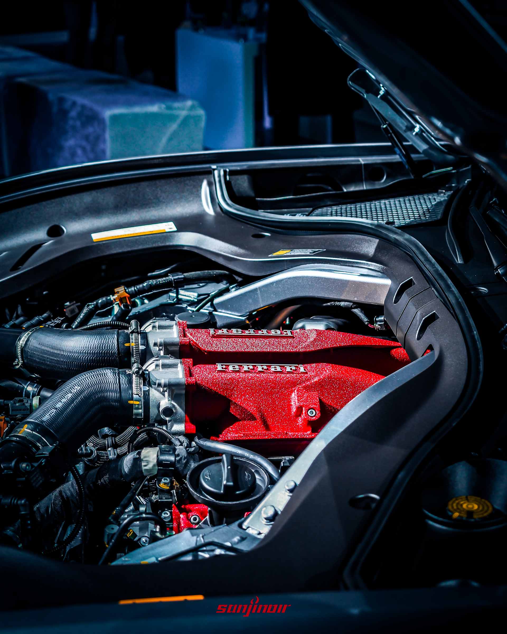 Ferrari Amalfi引擎室細部特寫，聚焦於紅色汽缸上蓋的Ferrari字樣與周邊管路細節。