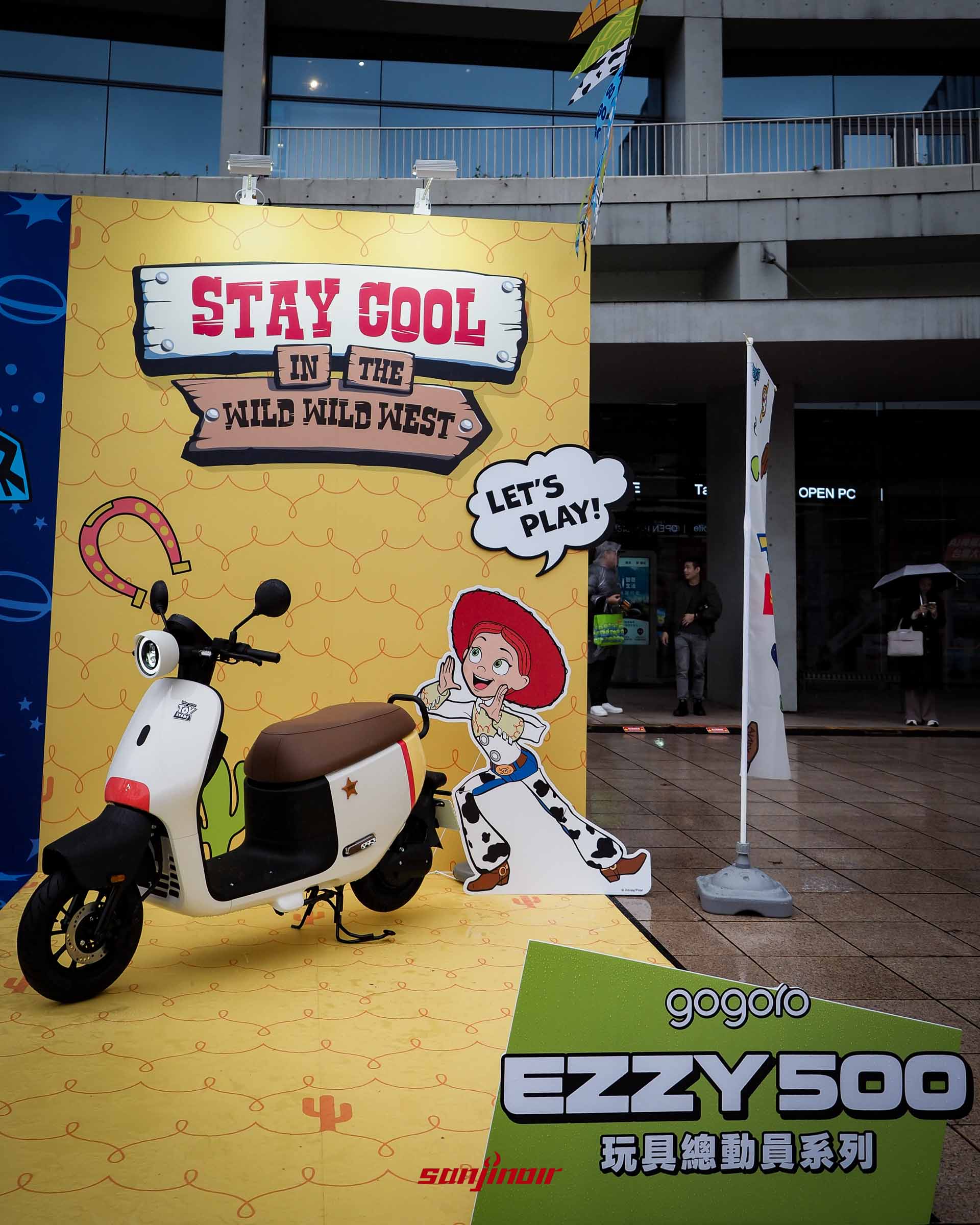 Gogoro EZZY 500歡樂牛仔號機車停放在翠絲主題造景前，車身為白紅黃配色。