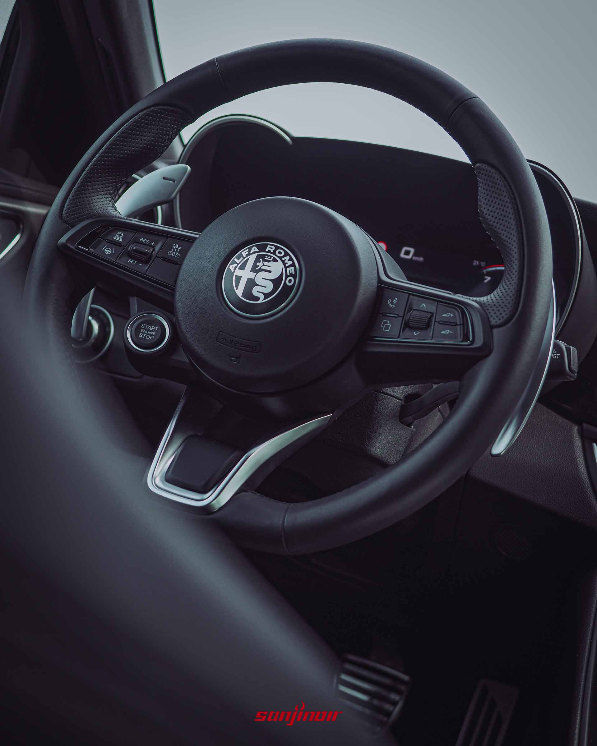 Alfa Romeo Giulia Sprint方向盤特寫,聚焦於引擎啟動鈕與金屬換檔撥片。