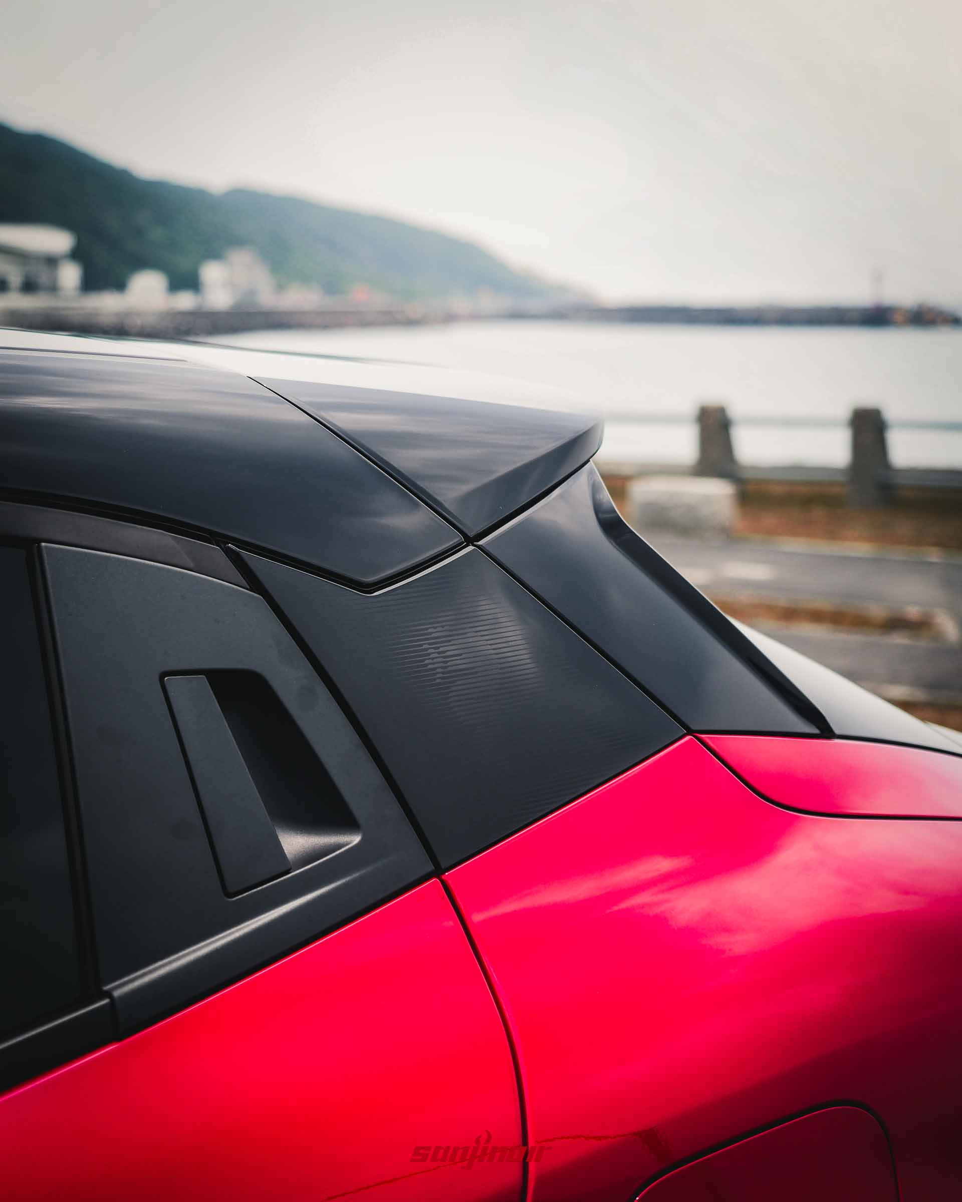 Alfa Romeo Junior C柱與後車門特寫,展示隱藏式門把與黑色飾板上的Alfa Romeo蛇形廠徽暗紋。